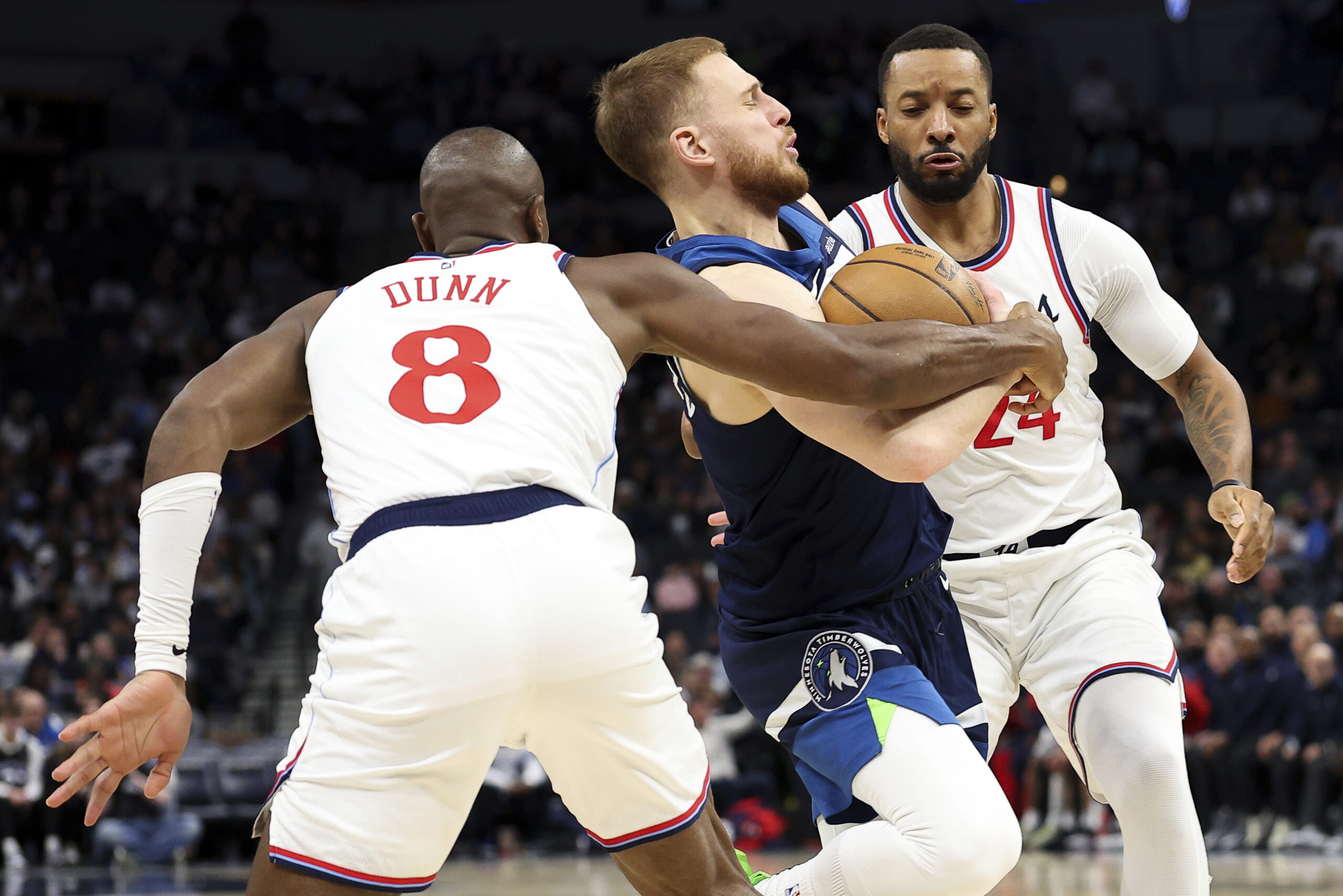 Minnesota Timberwolves guard Donte DiVincenzo, center, works toward the basket...