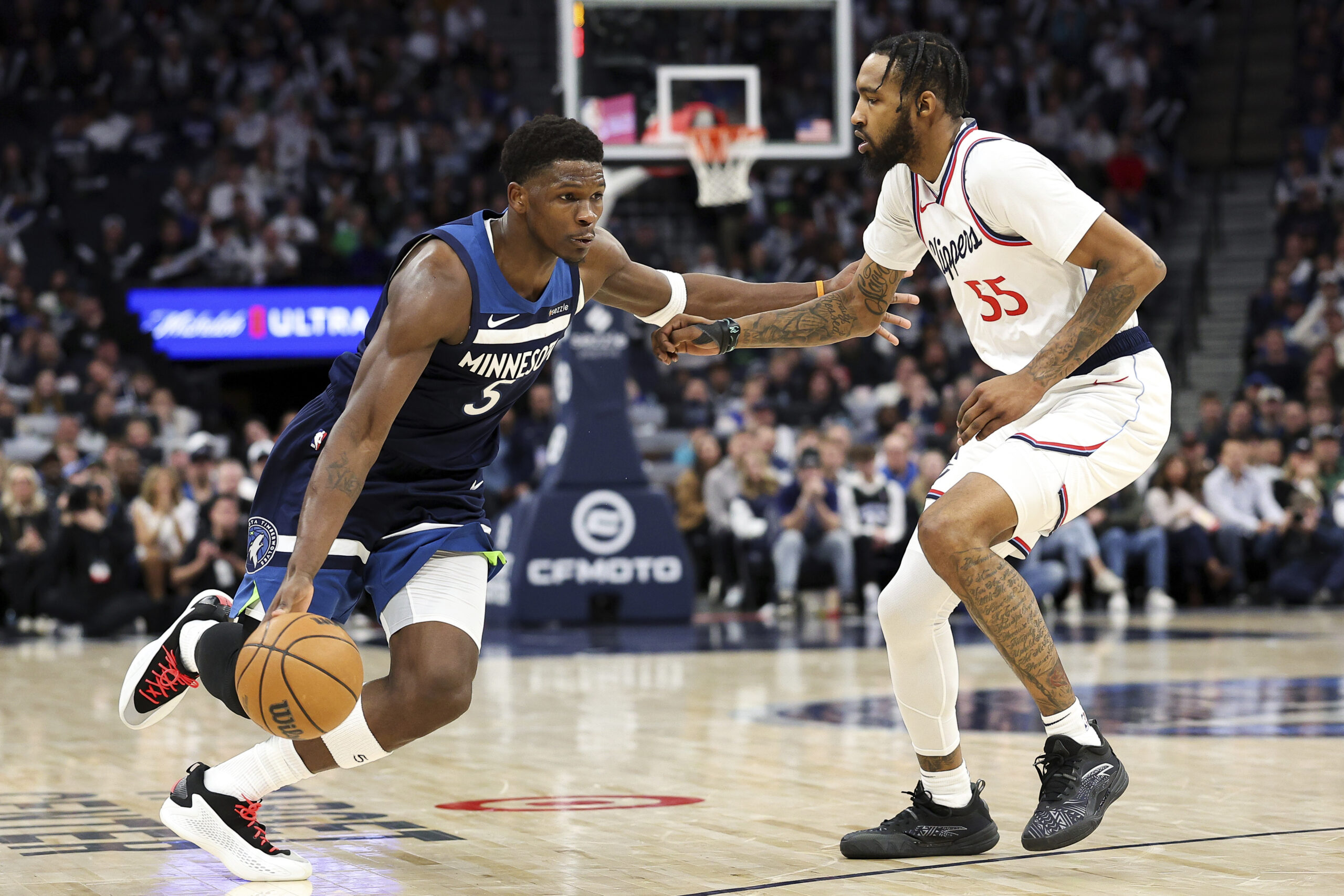 Minnesota Timberwolves guard Anthony Edwards, left, drives as Clippers forward...