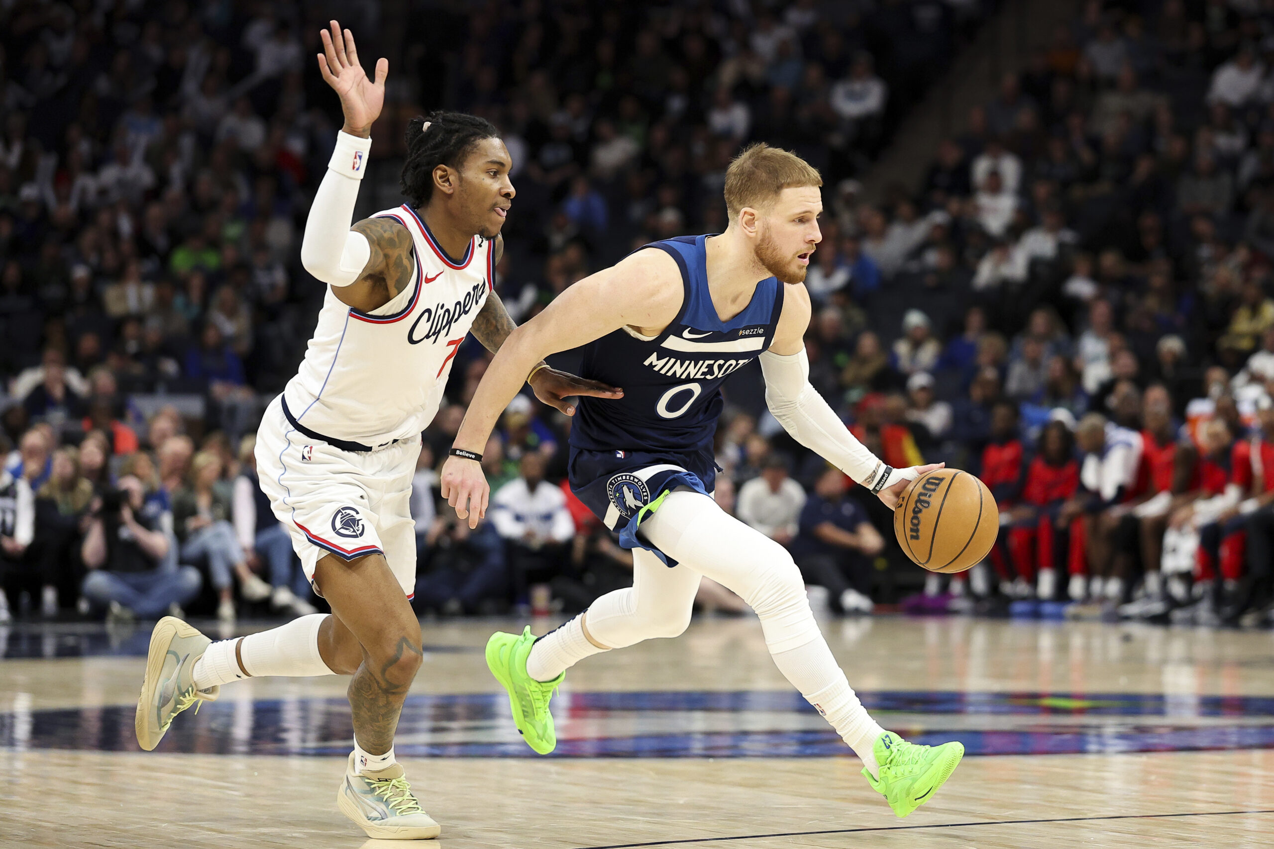 Minnesota Timberwolves guard Donte DiVincenzo, right, drives as Clippers guard...