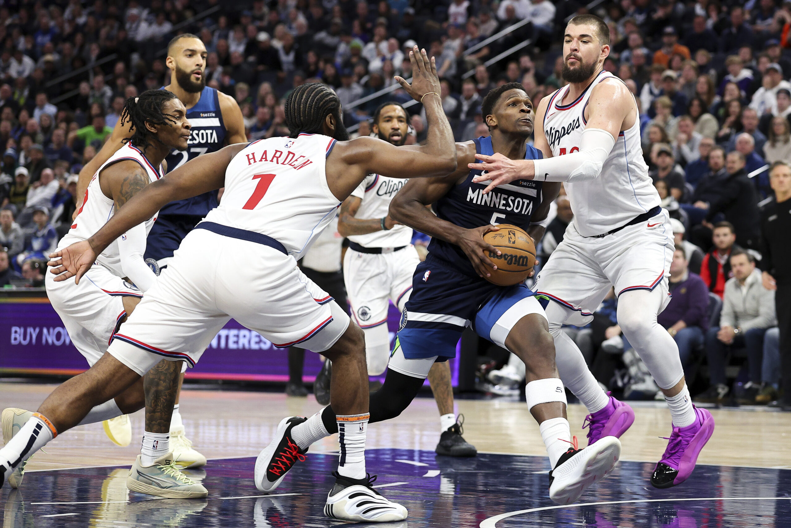 Minnesota Timberwolves star Anthony Edwards, center right, drives toward the...