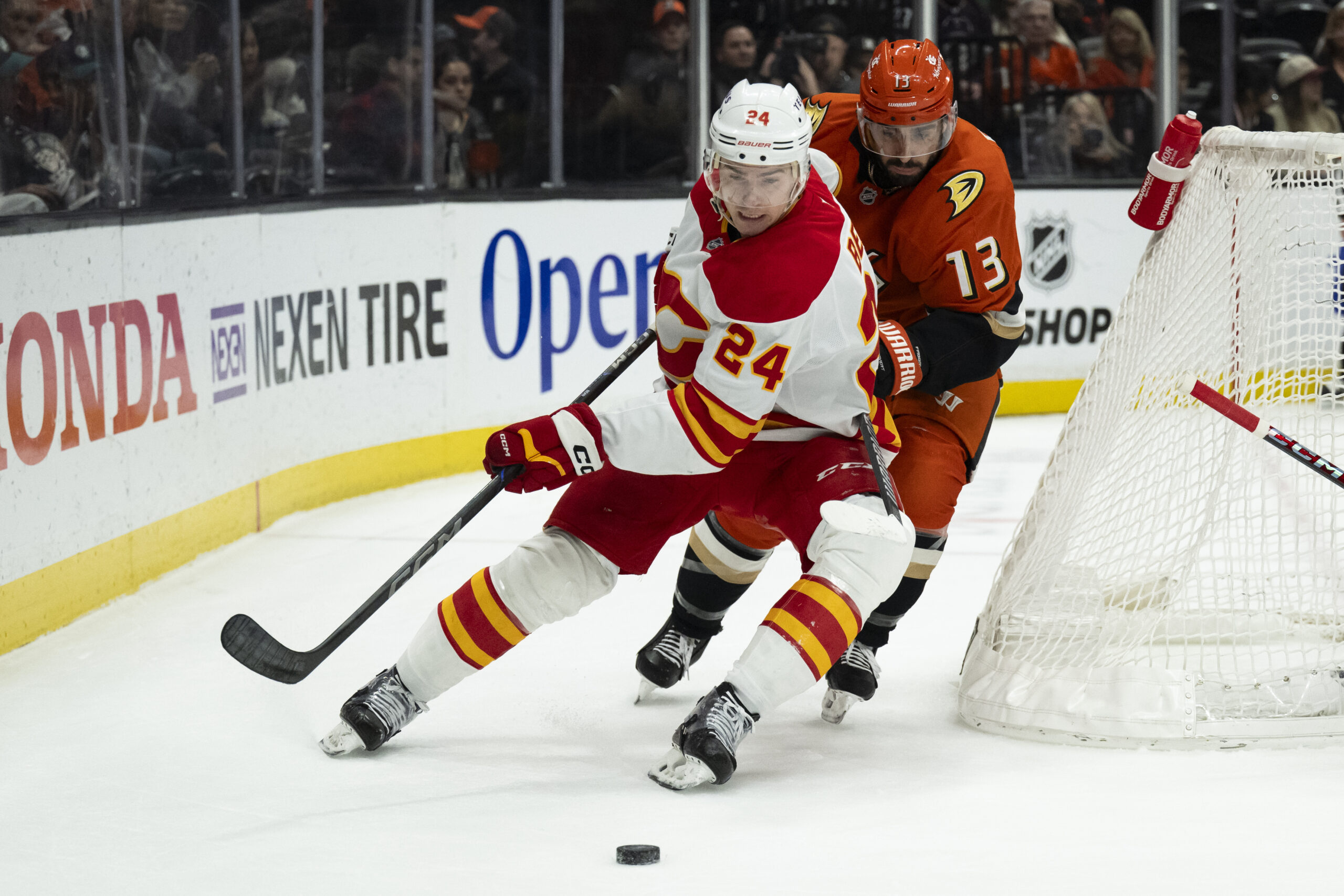 Calgary Flames defenseman Jake Bean (24) controls the puck as...