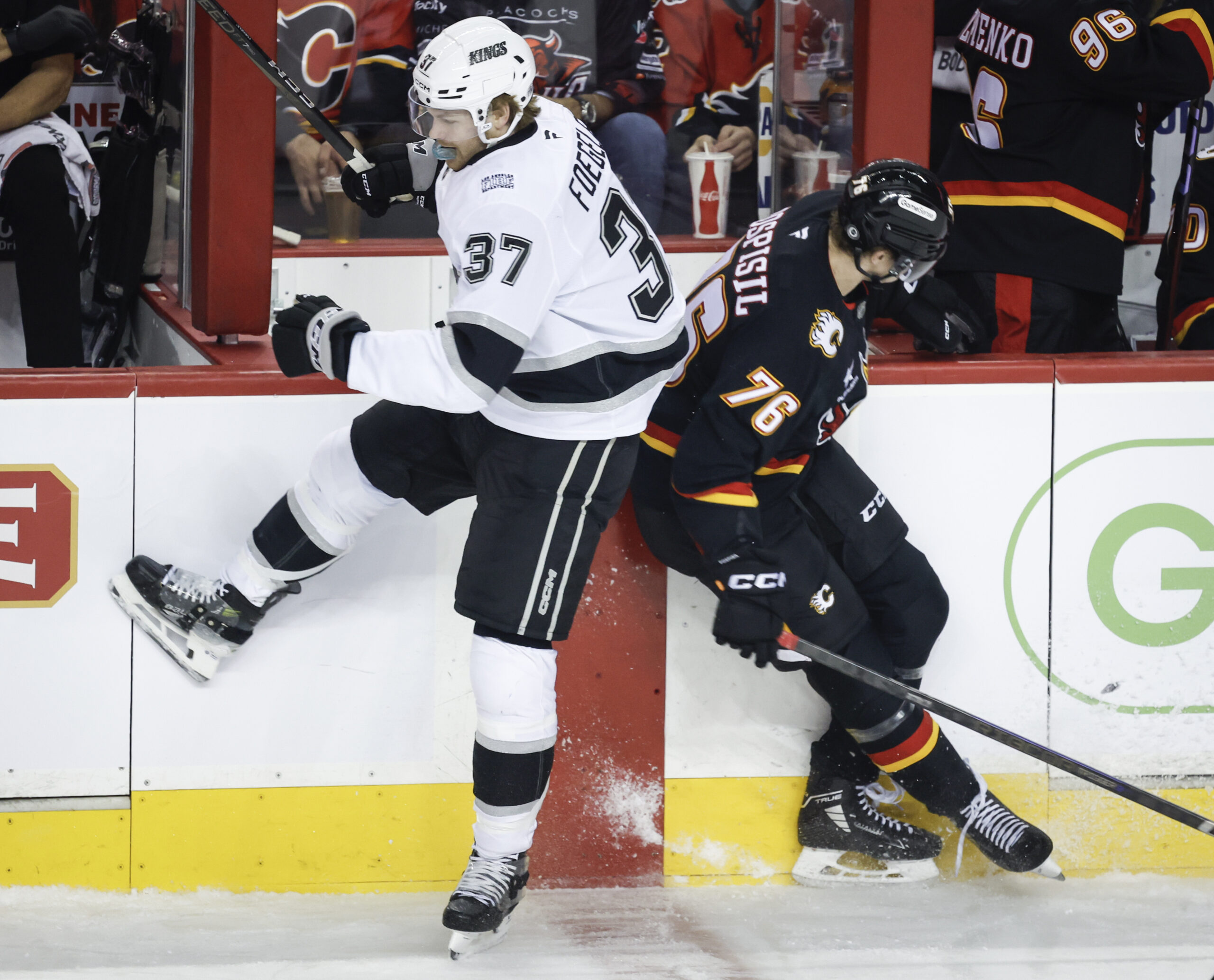 Kings’ Warren Foegele, left, checks Calgary Flames’ Martin Pospisil, right,...