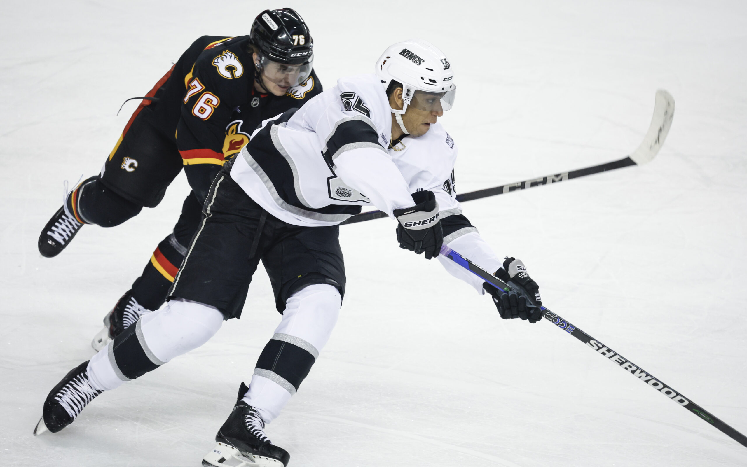 Kings’ Quinton Byfield, right, gets away from Calgary Flames’ Martin...