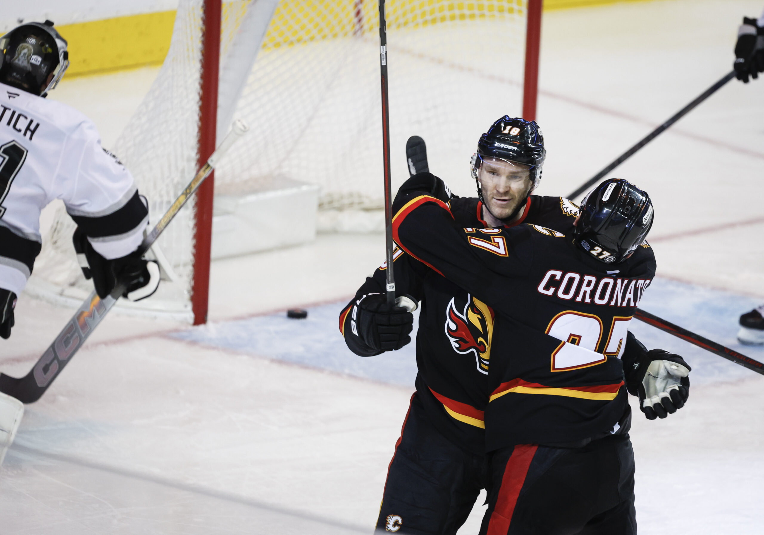 Calgary Flames’ Jonathan Huberdeau, left, celebrates his goal with teammate...