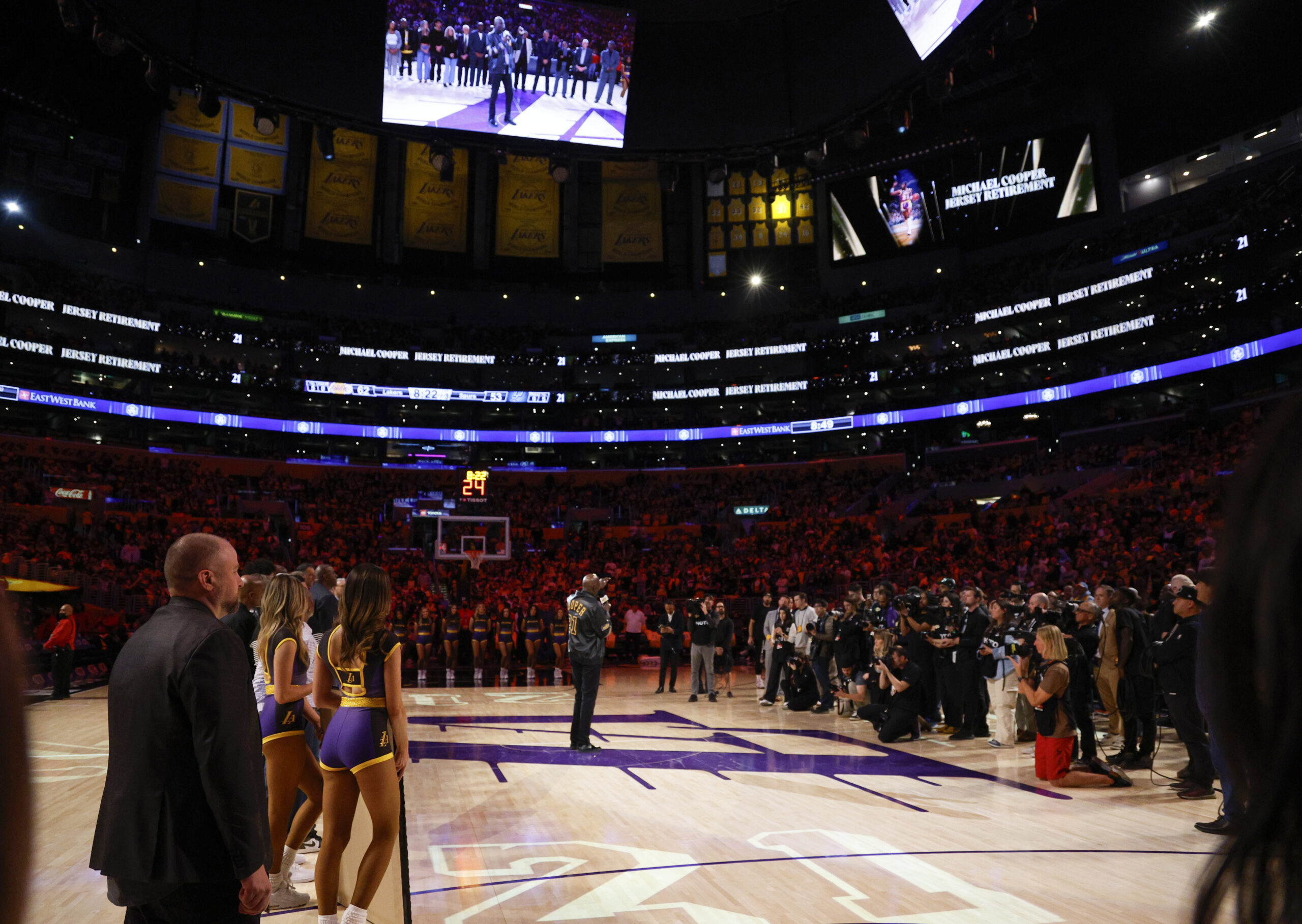 Former Lakers star Michael Cooper, center, speaks during his jersey...