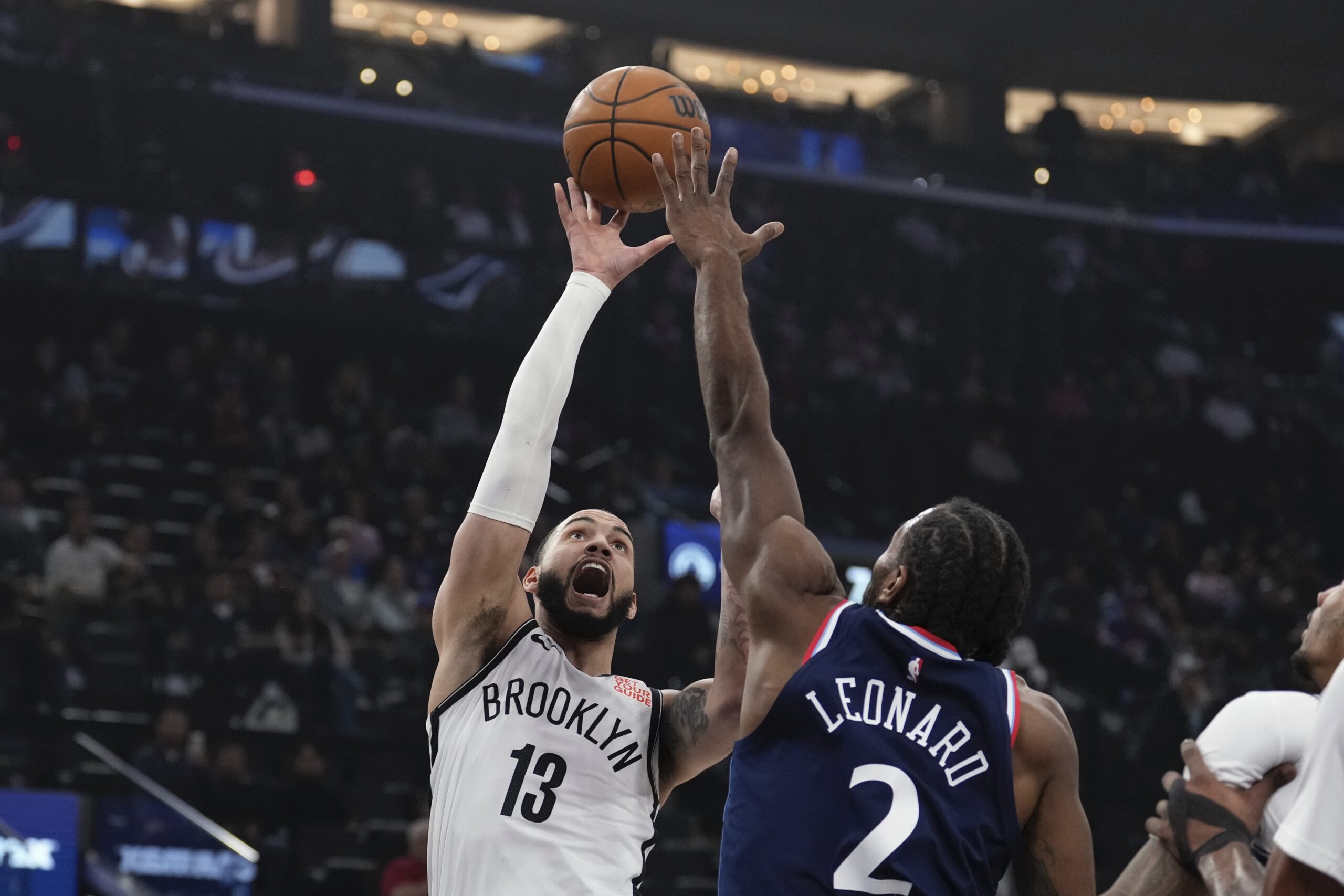 Brooklyn Nets guard Tyrese Martin, left shoots as Clippers forward...