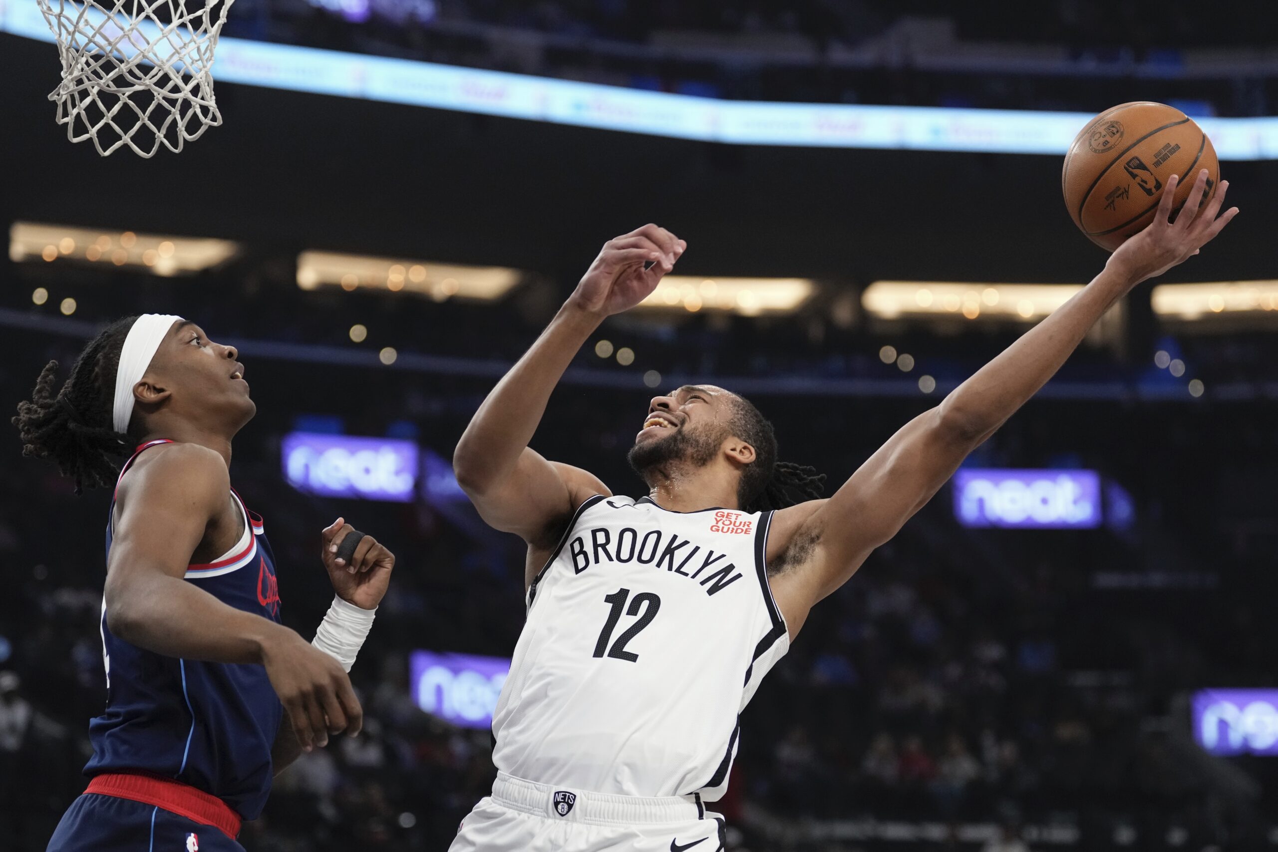 Brooklyn Nets forward Tosan Evbuomwanc right, shoots as Clippers guard...