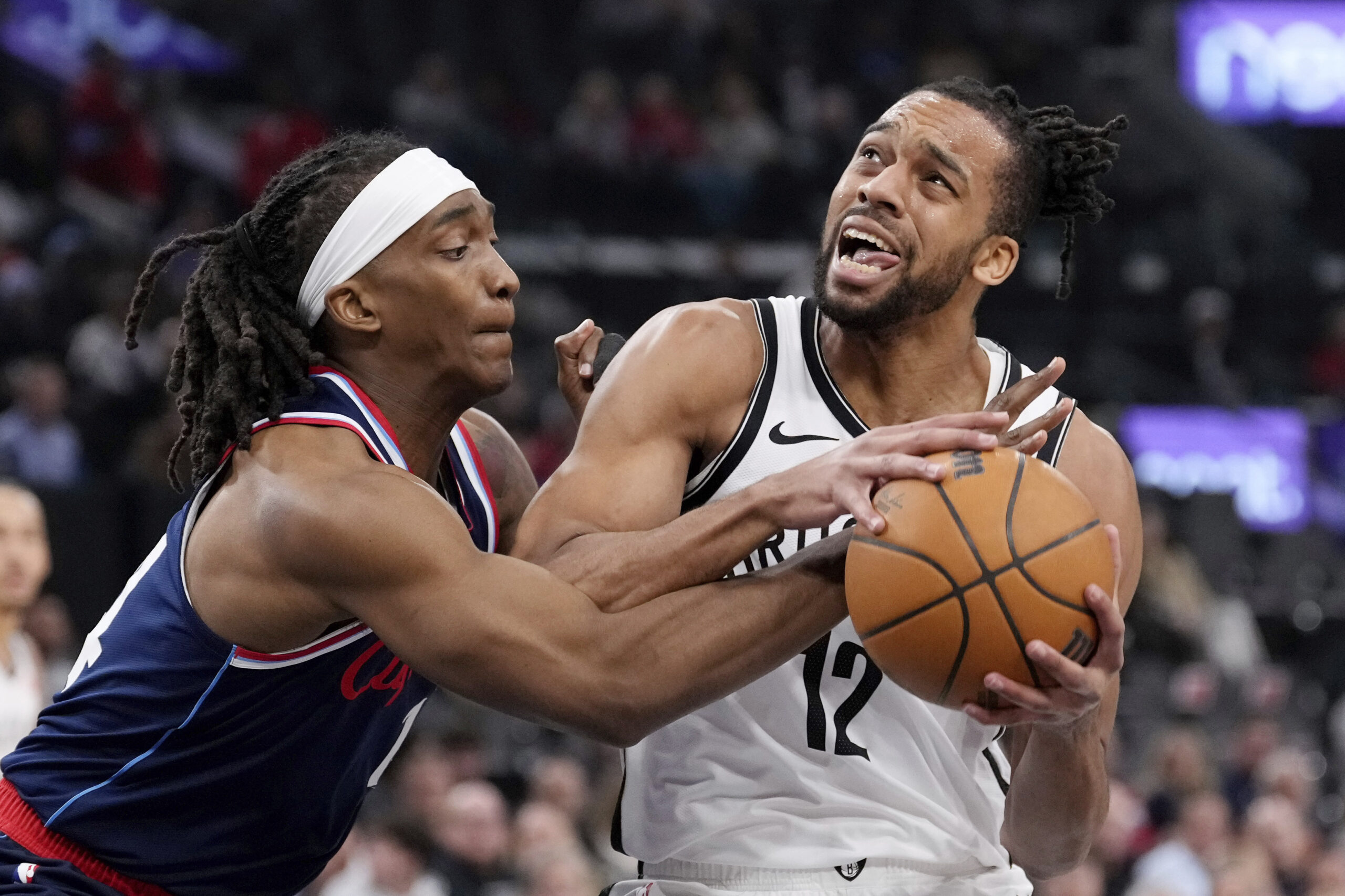 Clippers guard Terance Mann, left, reaches in on Brooklyn Nets...