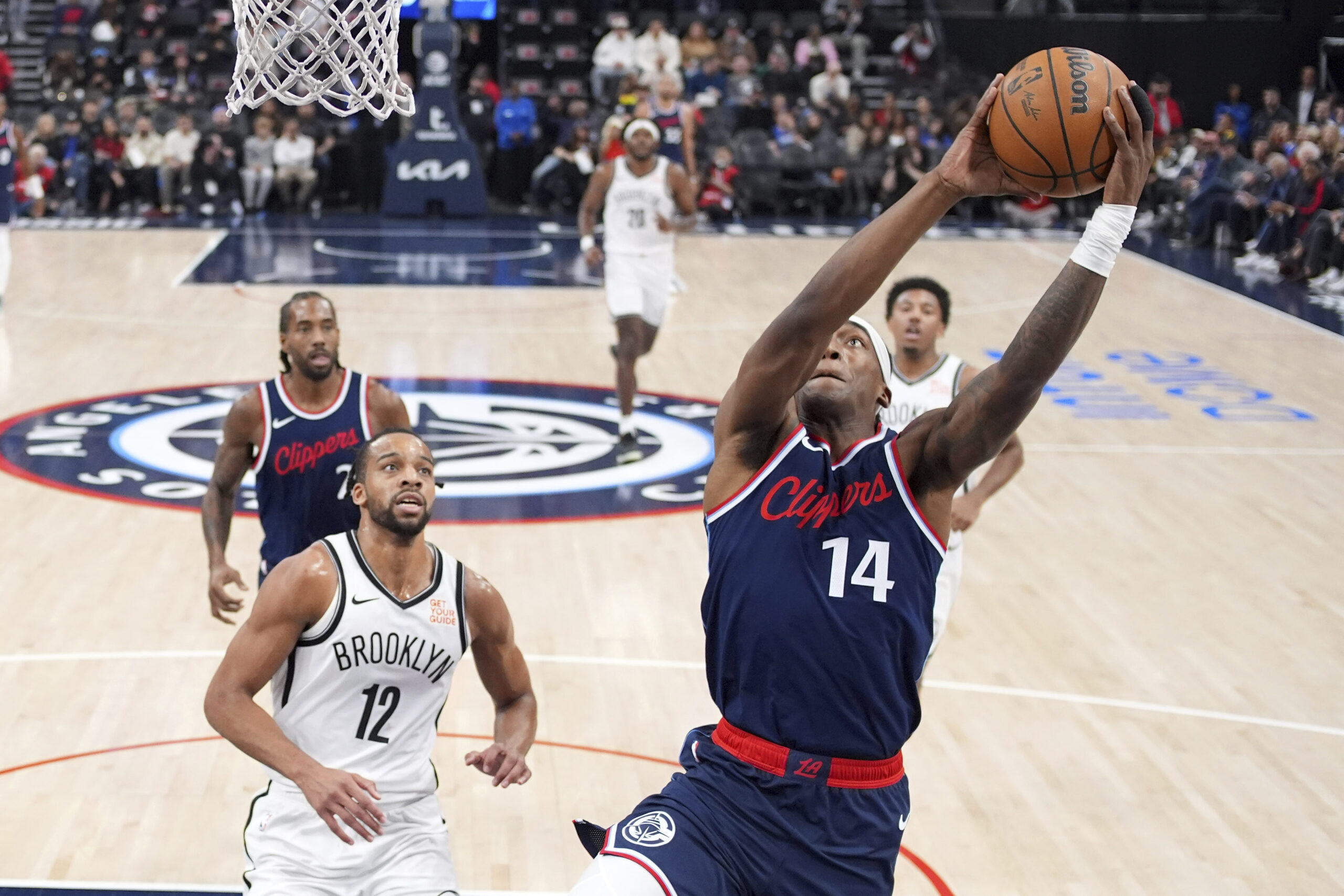 Clippers guard Terance Mann, right, shoots as Brooklyn Nets forward...