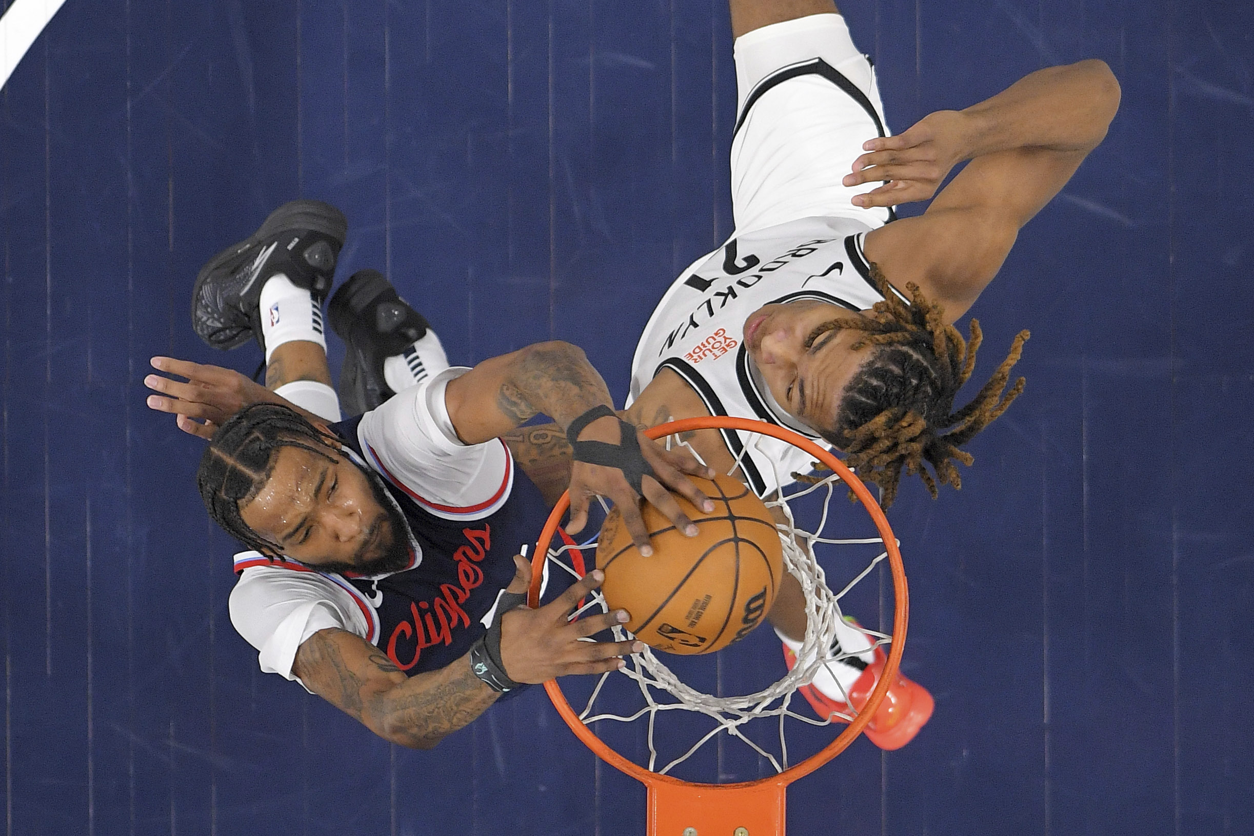 Clippers forward Derrick Jones Jr., left, dunks as Brooklyn Nets...