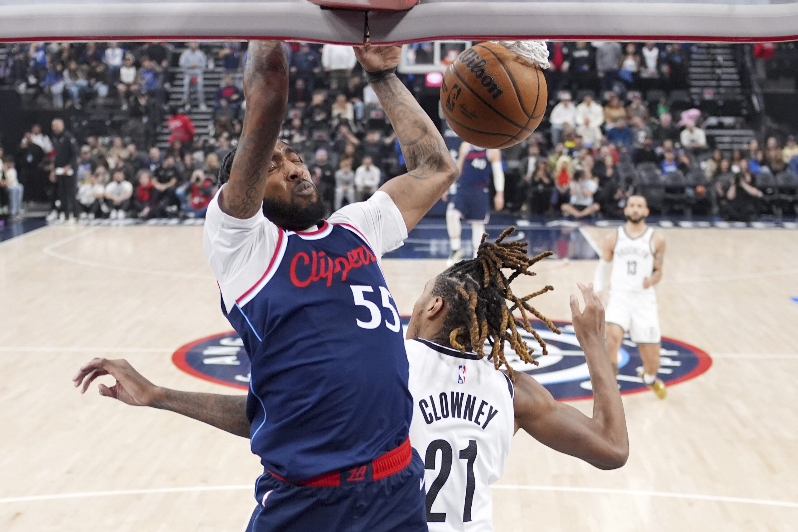 Clippers forward Derrick Jones Jr., left, dunks as Brooklyn Nets...