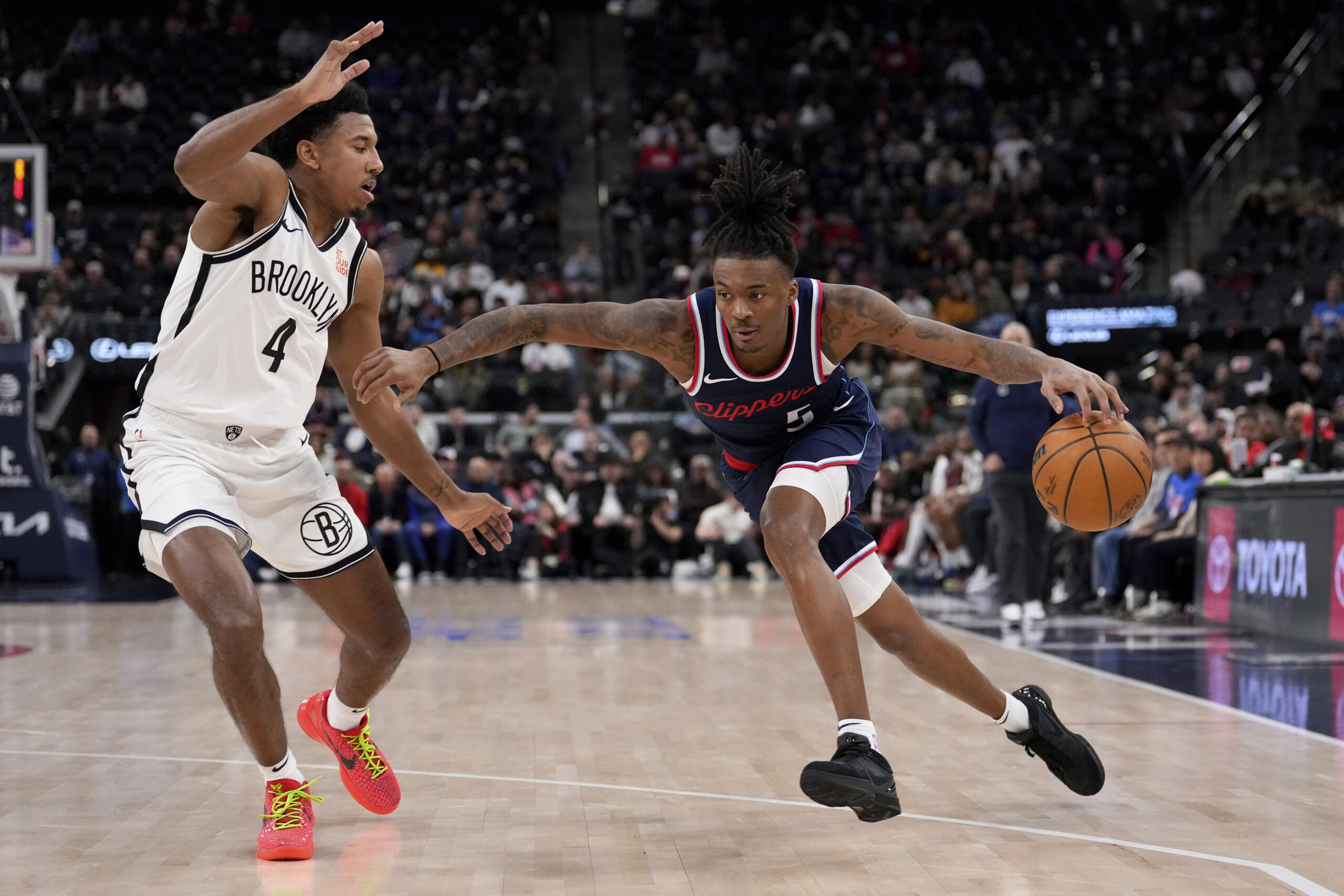 Clippers guard Bones Hyland, right, tries to drives by Brooklyn...