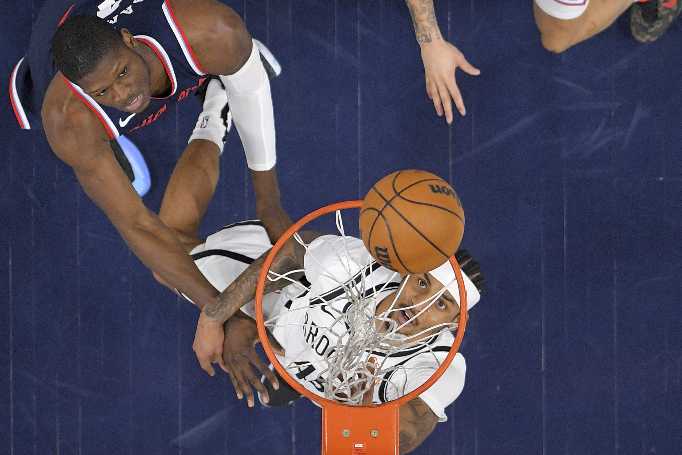 Brooklyn Nets guard Keon Johnson, right, watches his shot go...