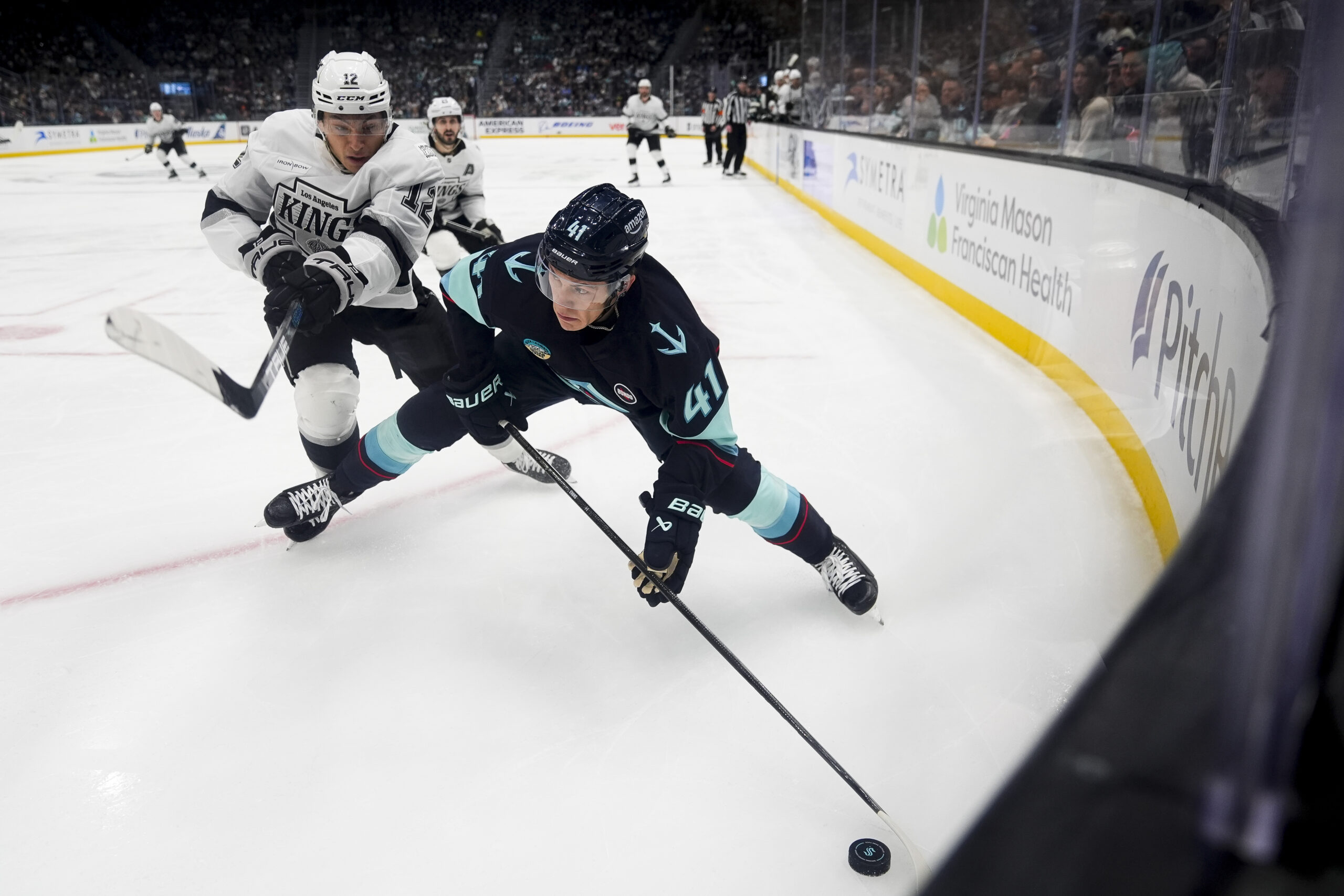 Seattle Kraken defenseman Ryker Evans (41) moves the puck around...