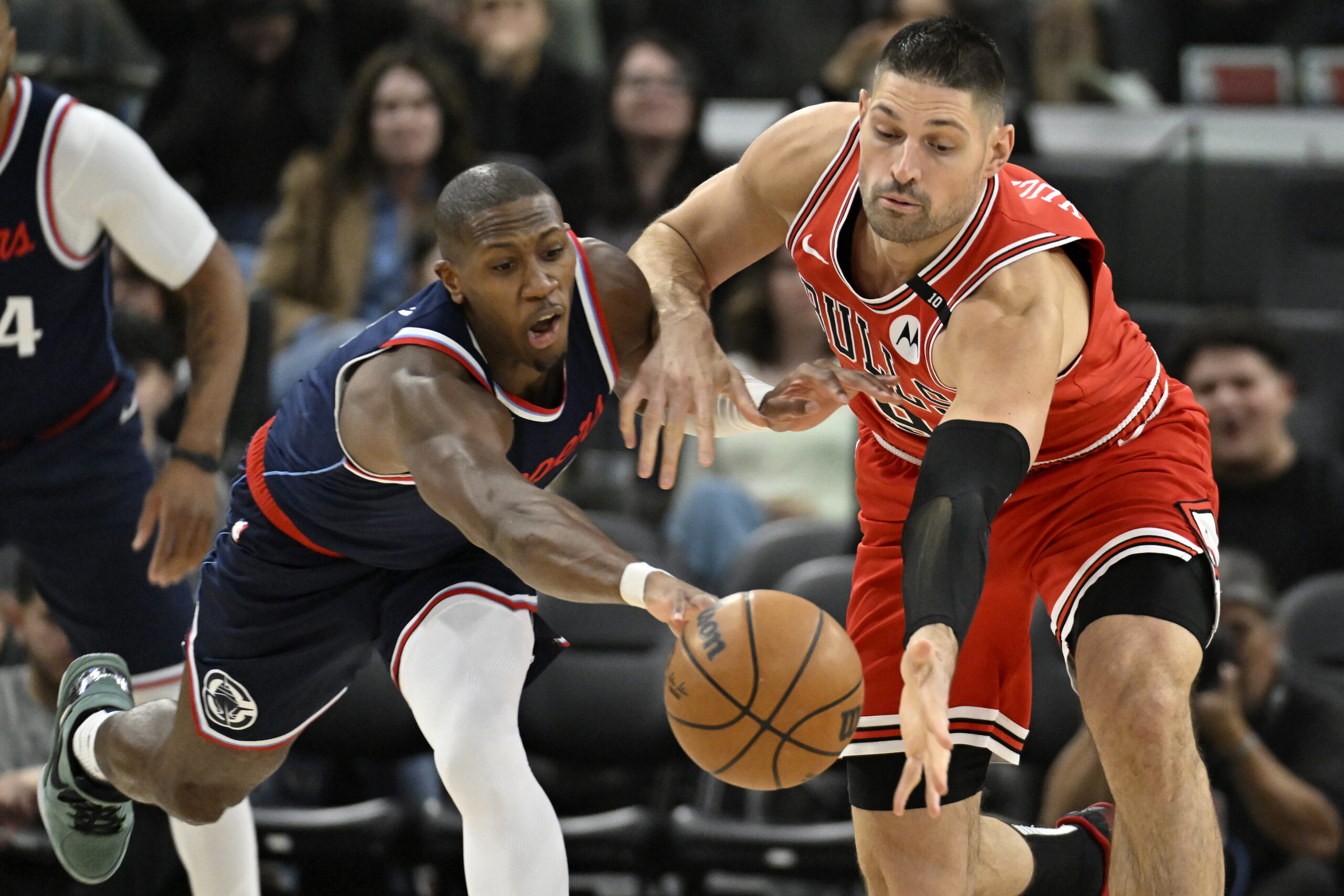 Clippers guard Kris Dunn, left, vies for the ball with...