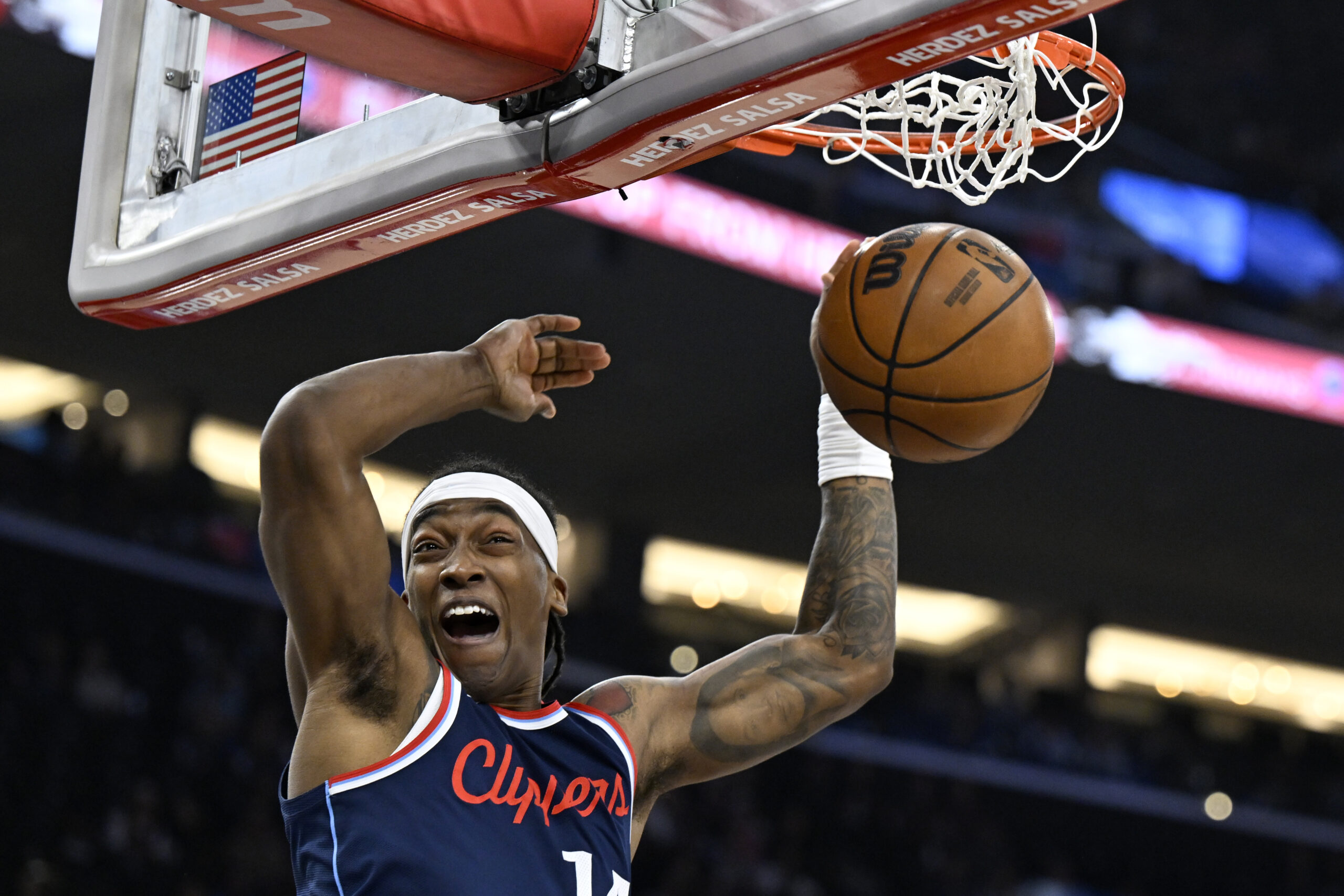 Clippers guard Terance Mann reacts after dunking against the Chicago...