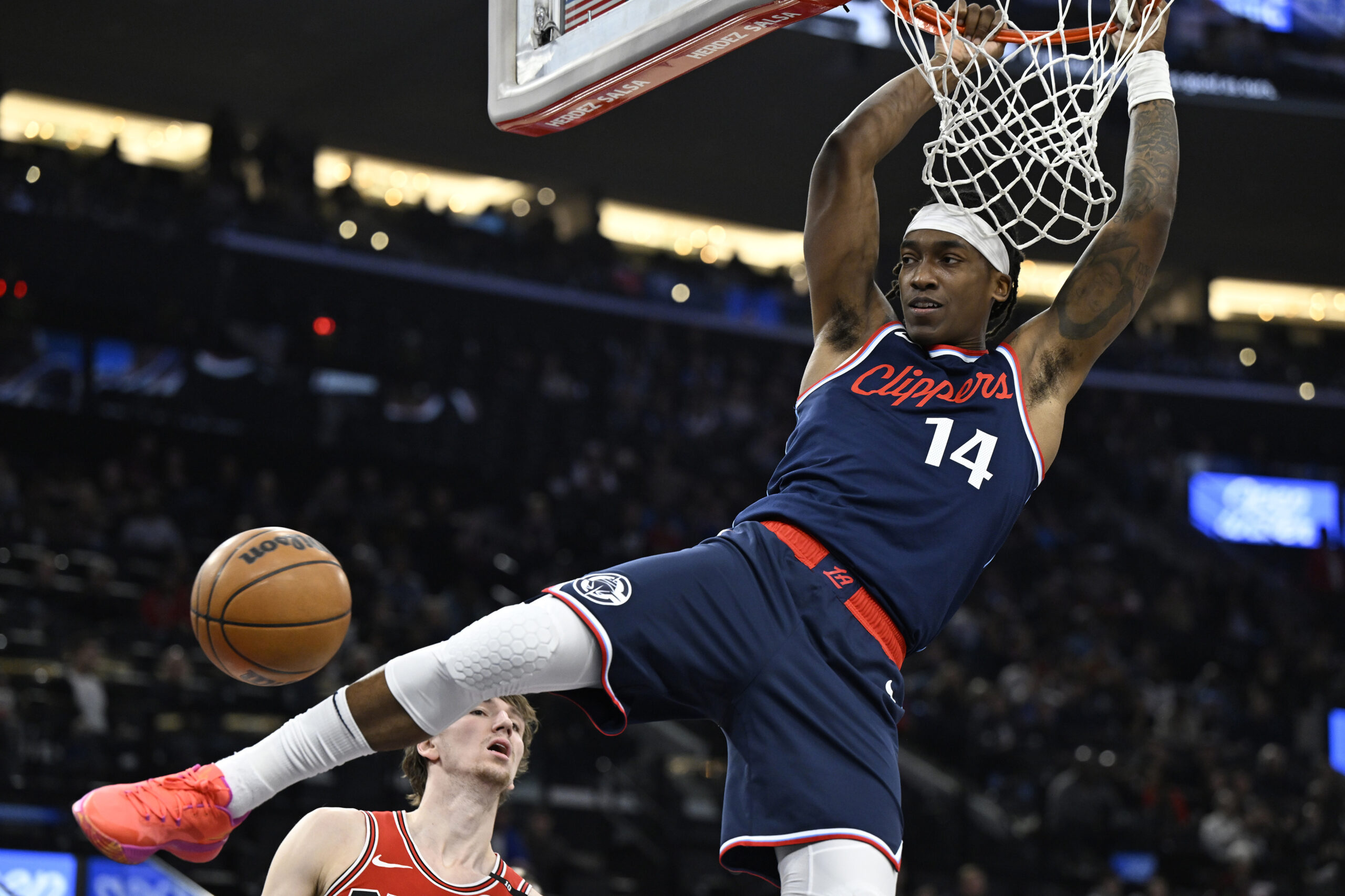 Clippers guard Terance Mann (14) hangs from the rim after...