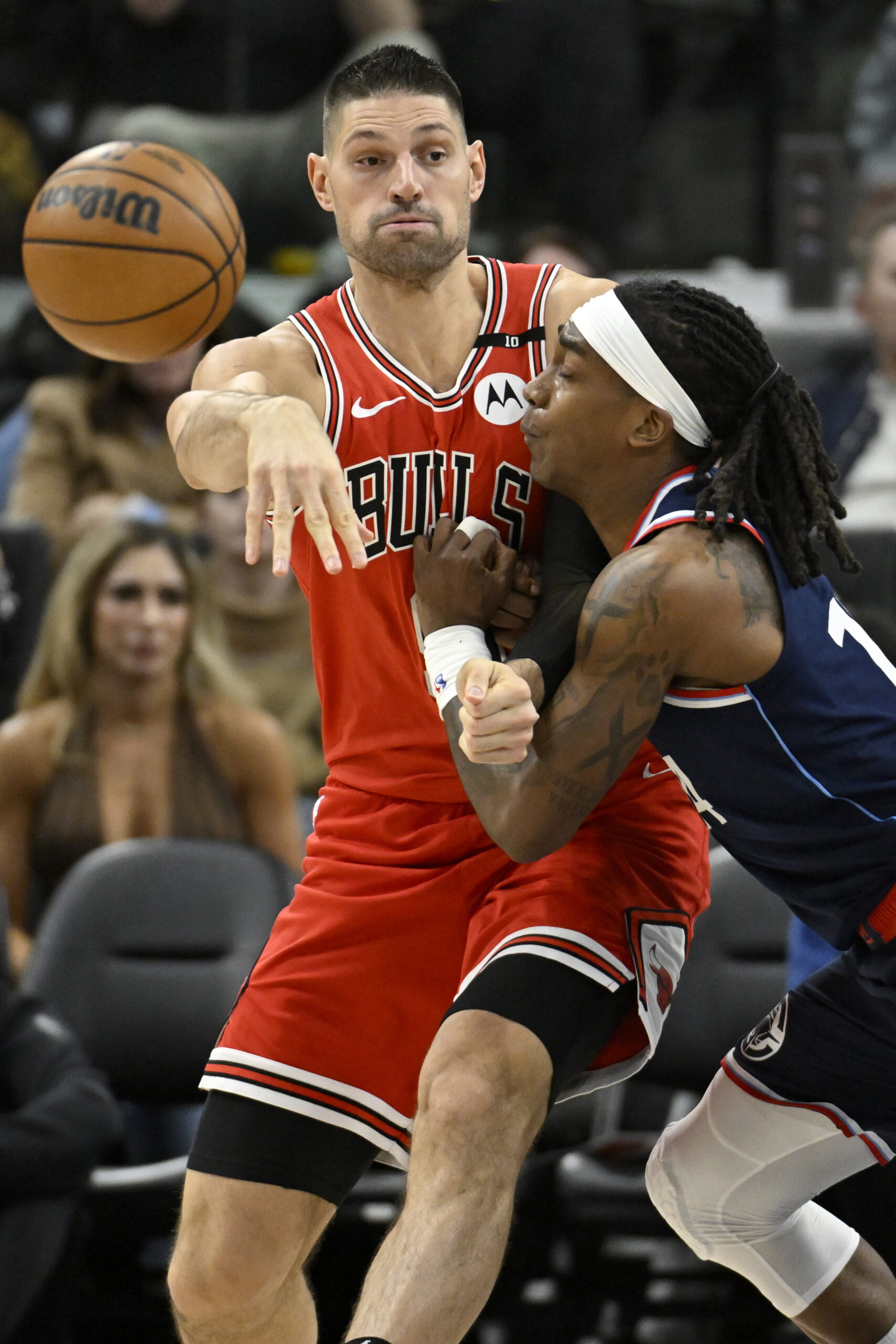 Chicago Bulls center Nikola Vucevic, left, passes the ball while...