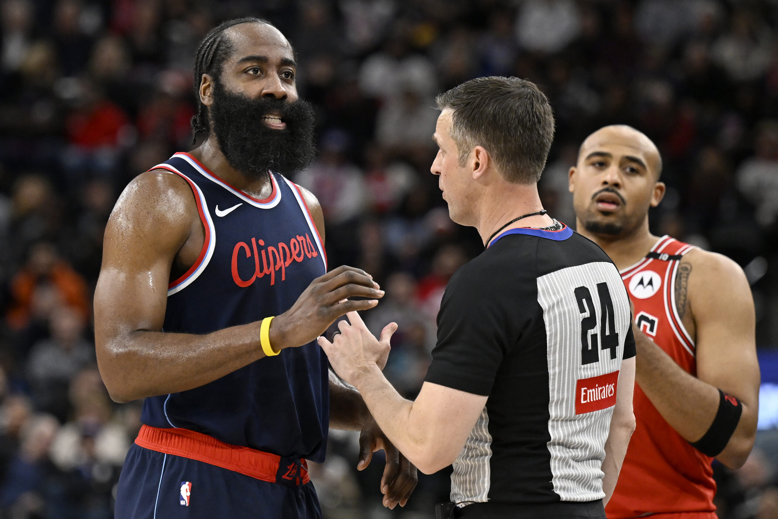 Clippers guard James Harden, left, chats with referee Kevin Scott...