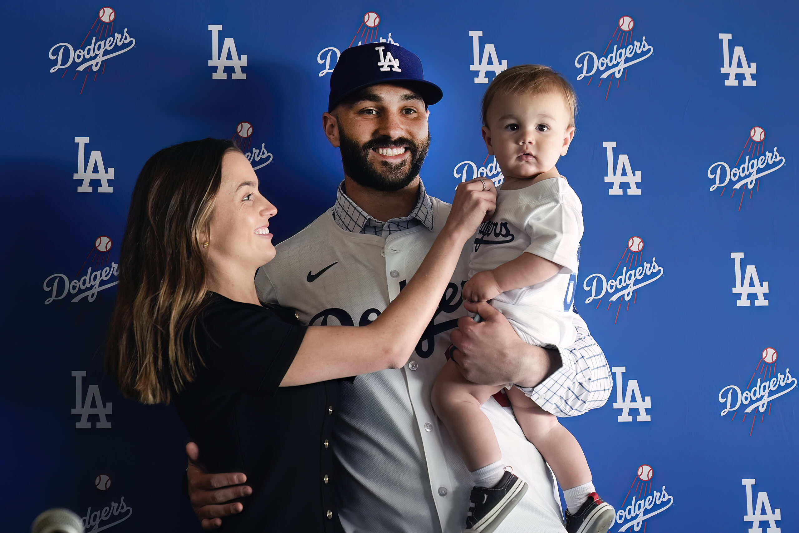 New Dodgers relief pitcher Tanner Scott, center, is joined by...