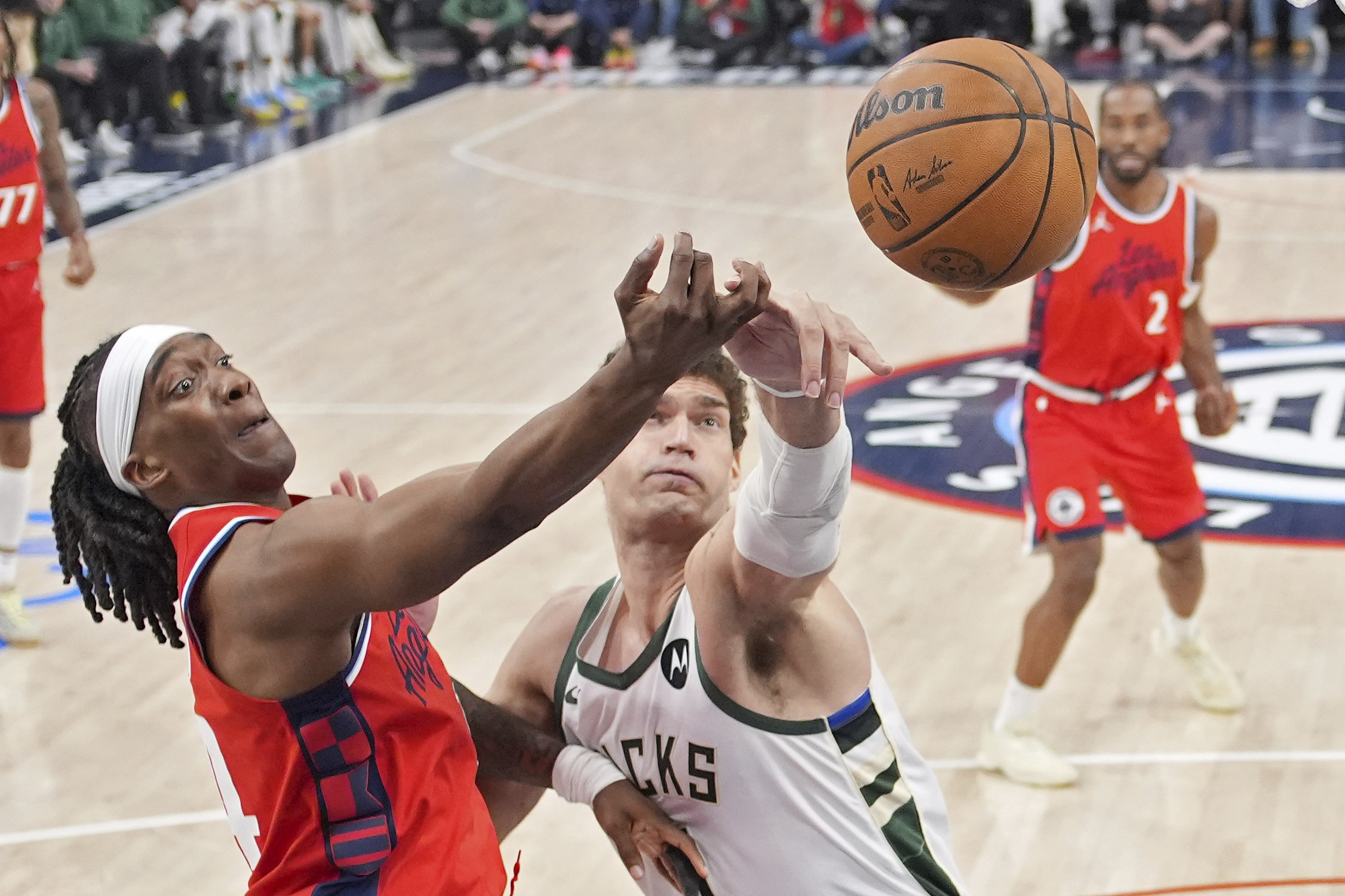 Clippers guard Terance Mann, left, and Milwaukee Bucks center Brook...