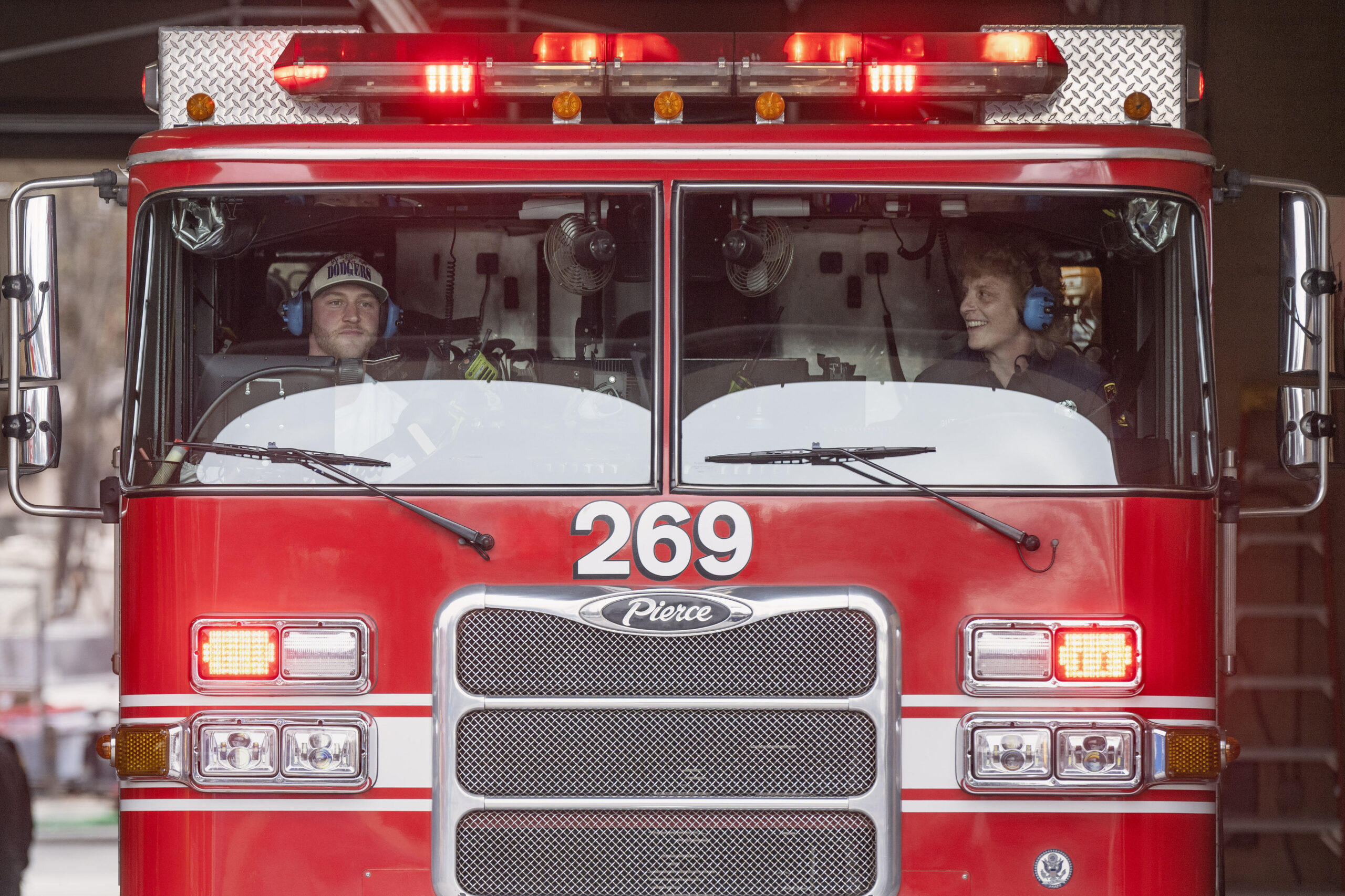 Dodgers pitcher Ben Casparius, left, rides in a fire engine...