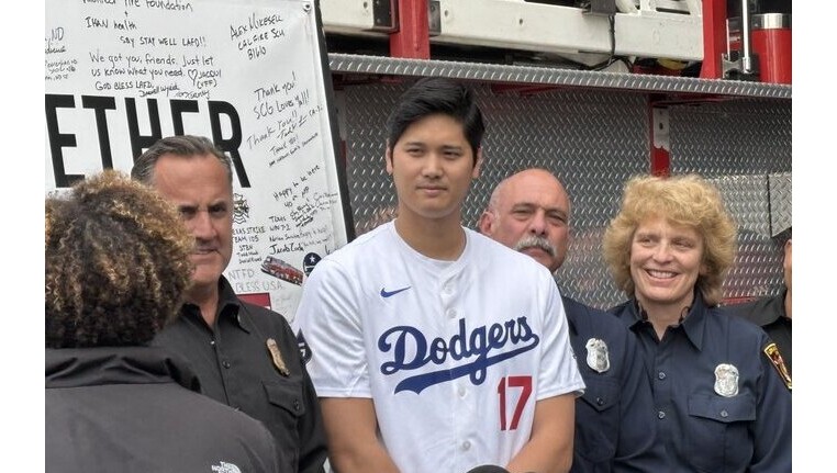 Dodgers star Shohei Ohtani poses with firefighters during a visit...