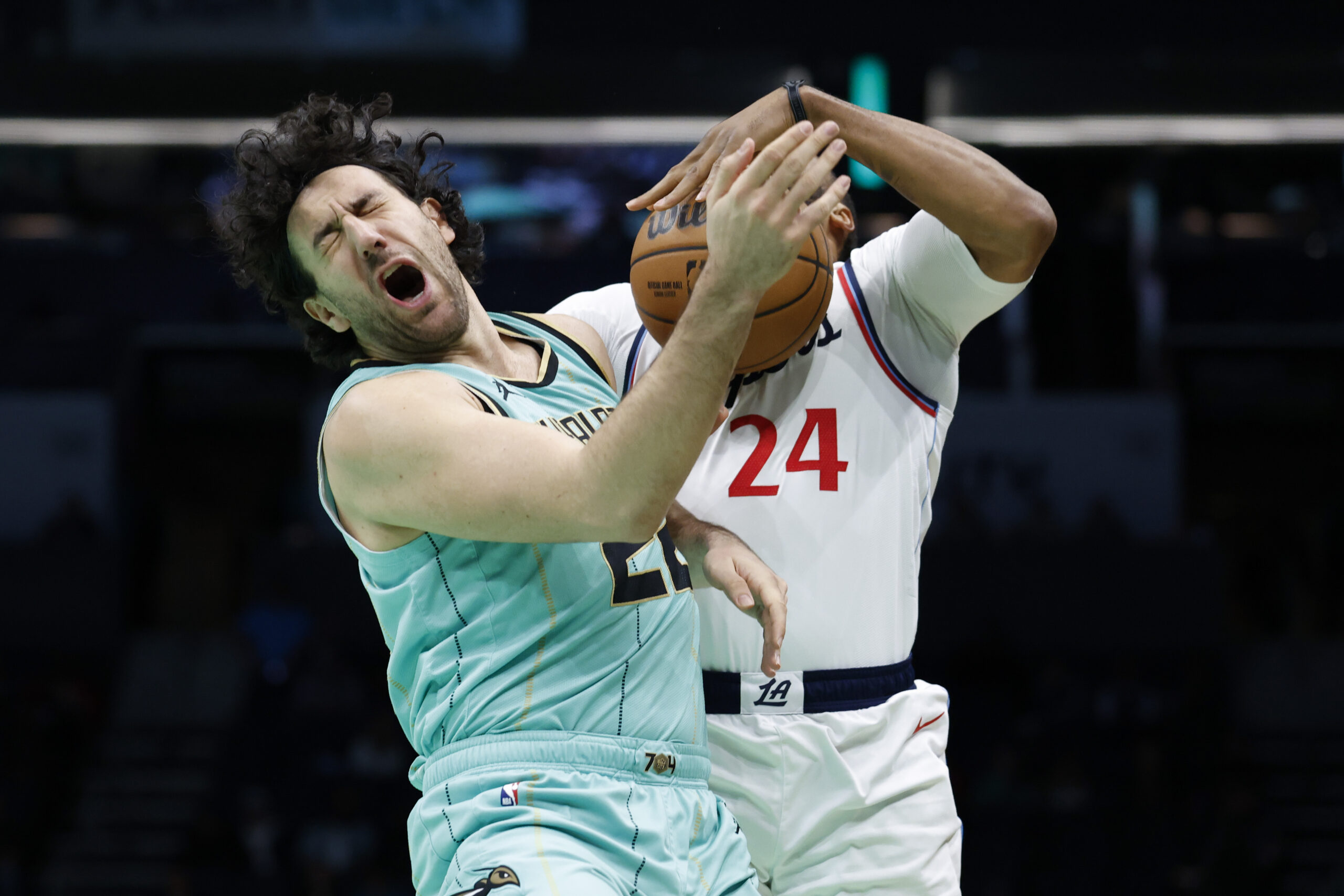 Charlotte Hornets guard Vasa Micic, left, reacts after colliding with...