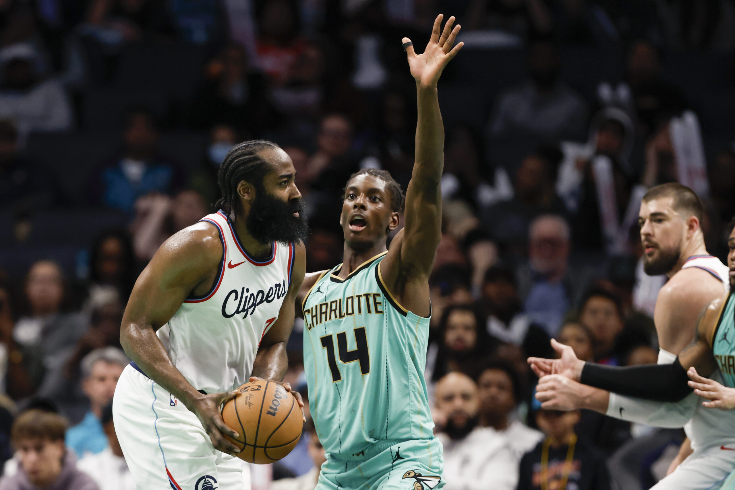 Clippers guard James Harden, left, looks to pass the ball...