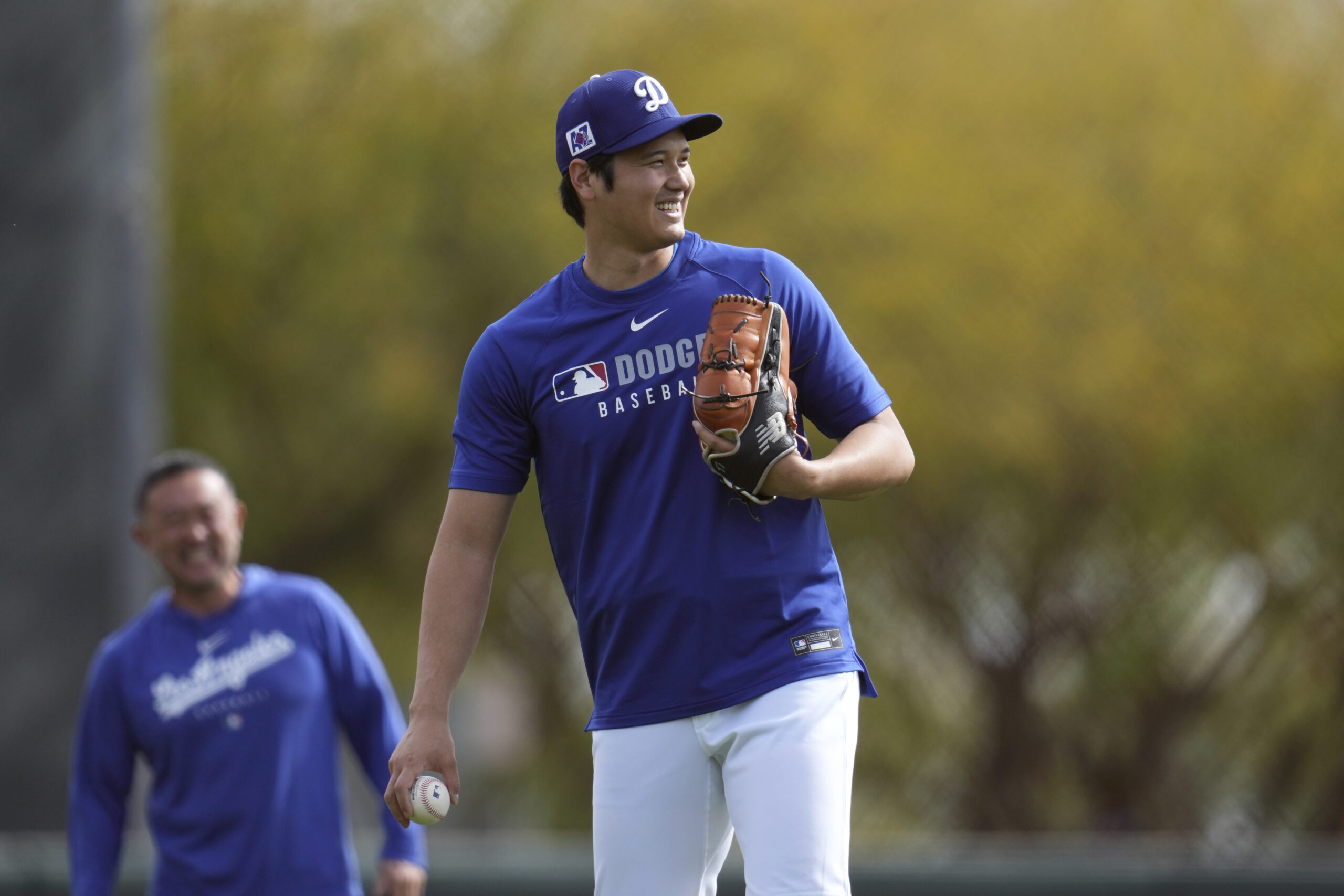 Dodgers star Shohei Ohtani smiles as he warms up on...