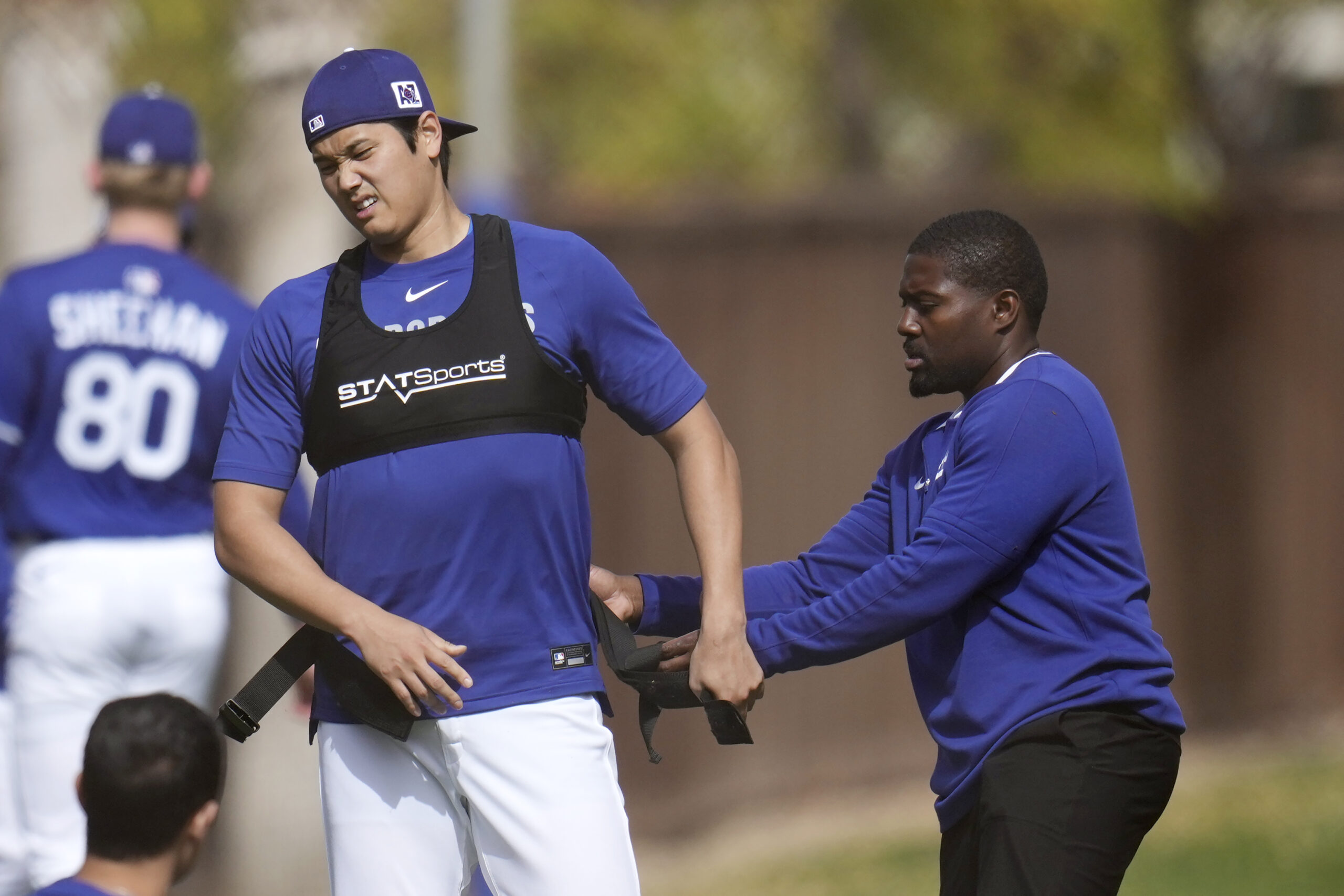 Dodgers star Shohei Ohtani, left, gets some help getting out...