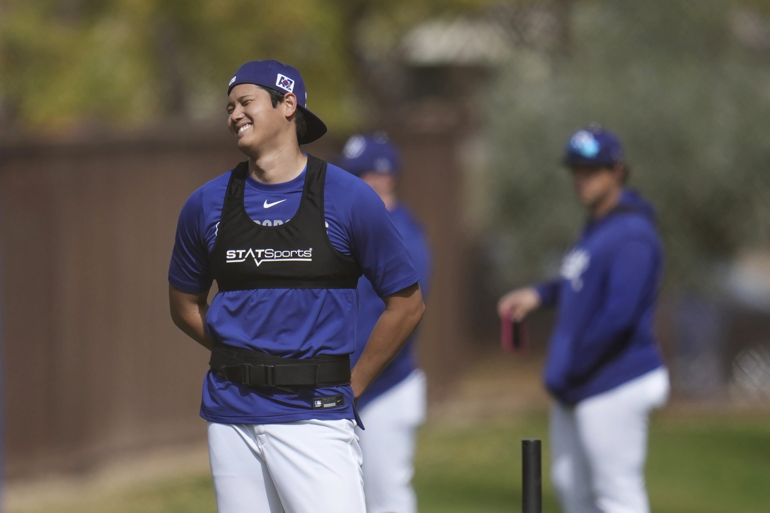 Dodgers star Shohei Ohtani laughs as the talks with teammates...