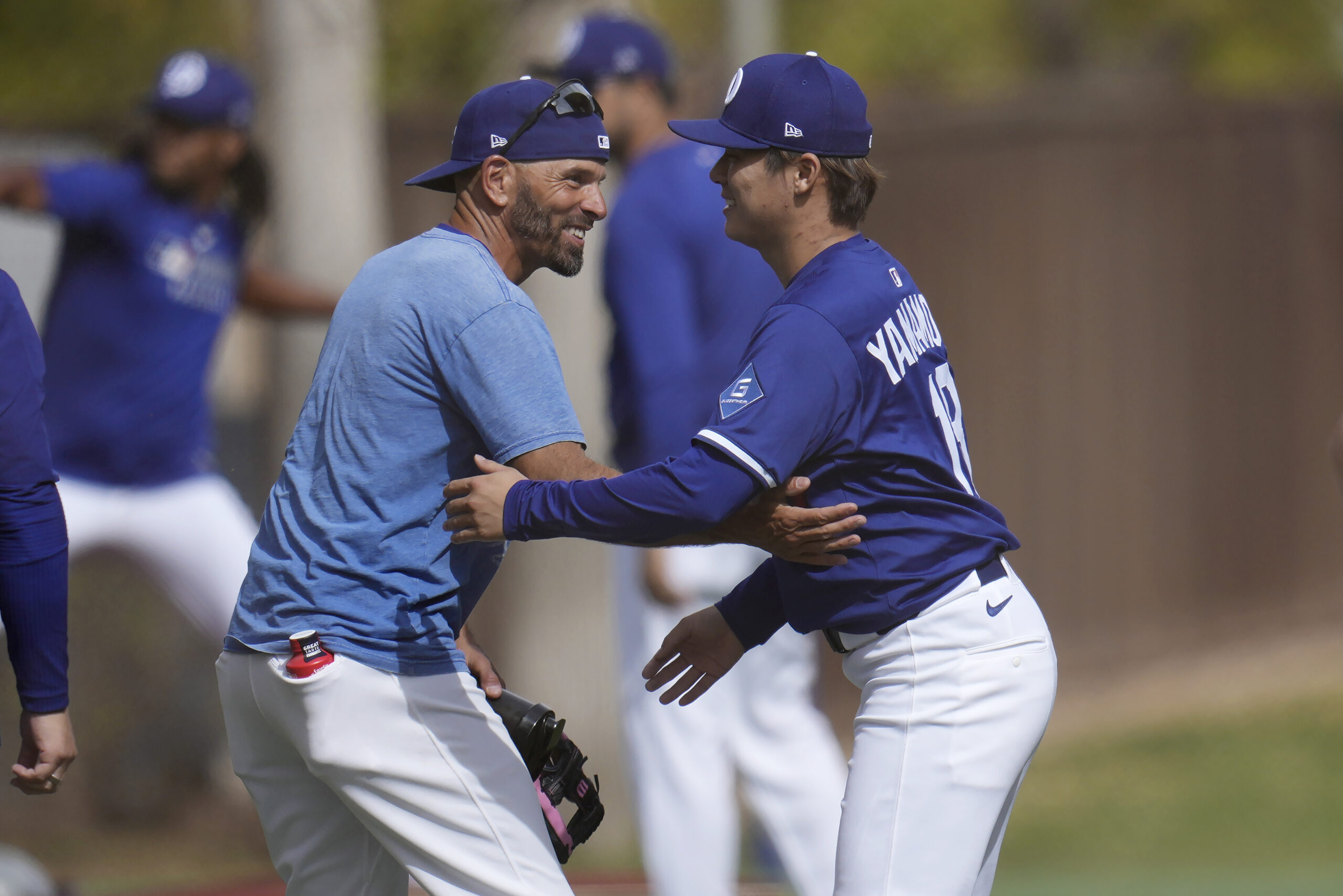 Dodgers pitcher Yoshinobu Yamamoto, right, gets a smile and a...