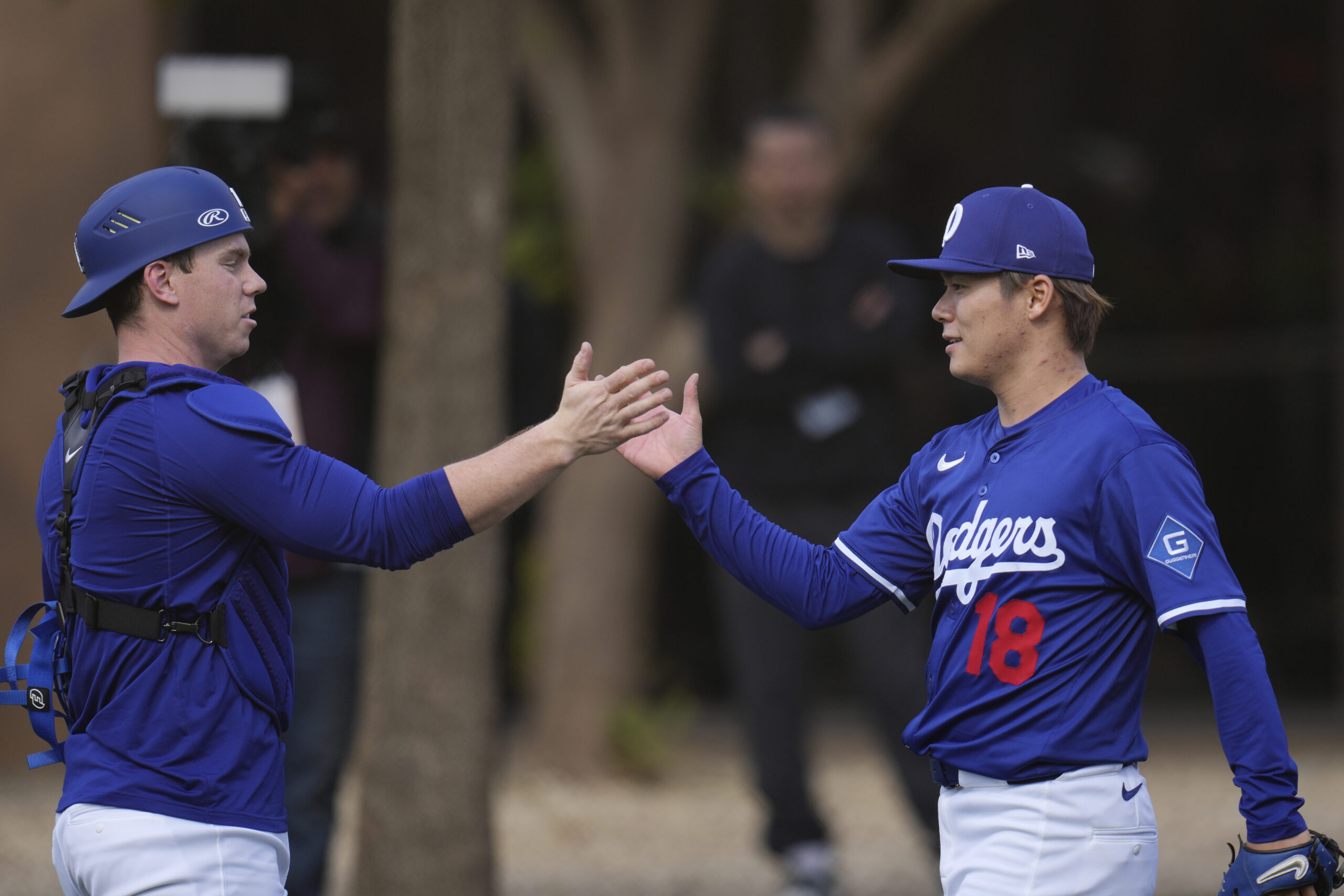 Dodgers pitcher Yoshinobu Yamamoto, right, slaps hands with catcher Will...