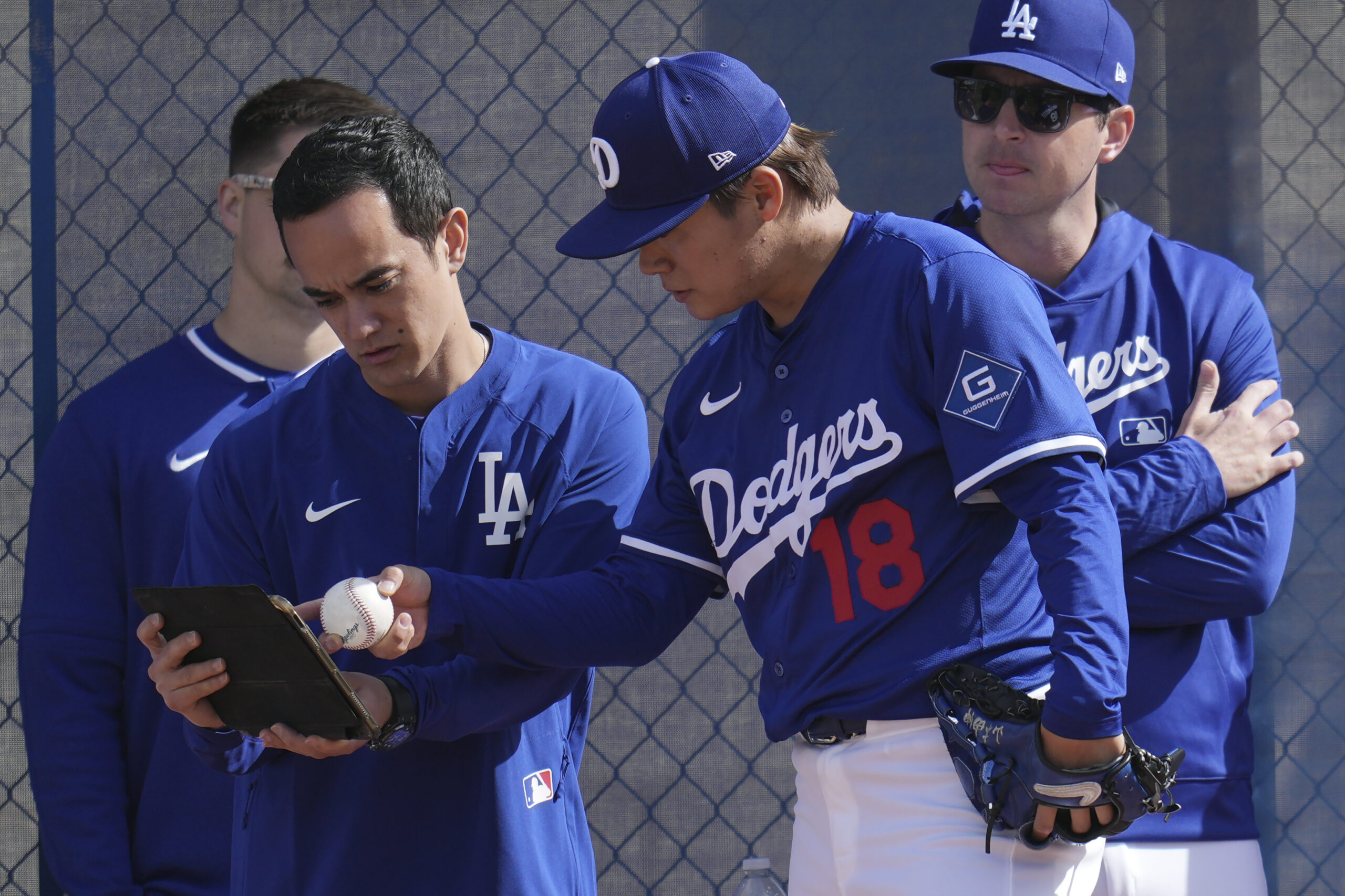 Dodgers pitcher Yoshinobu Yamamoto (18) talks with Will Ireton, left,...