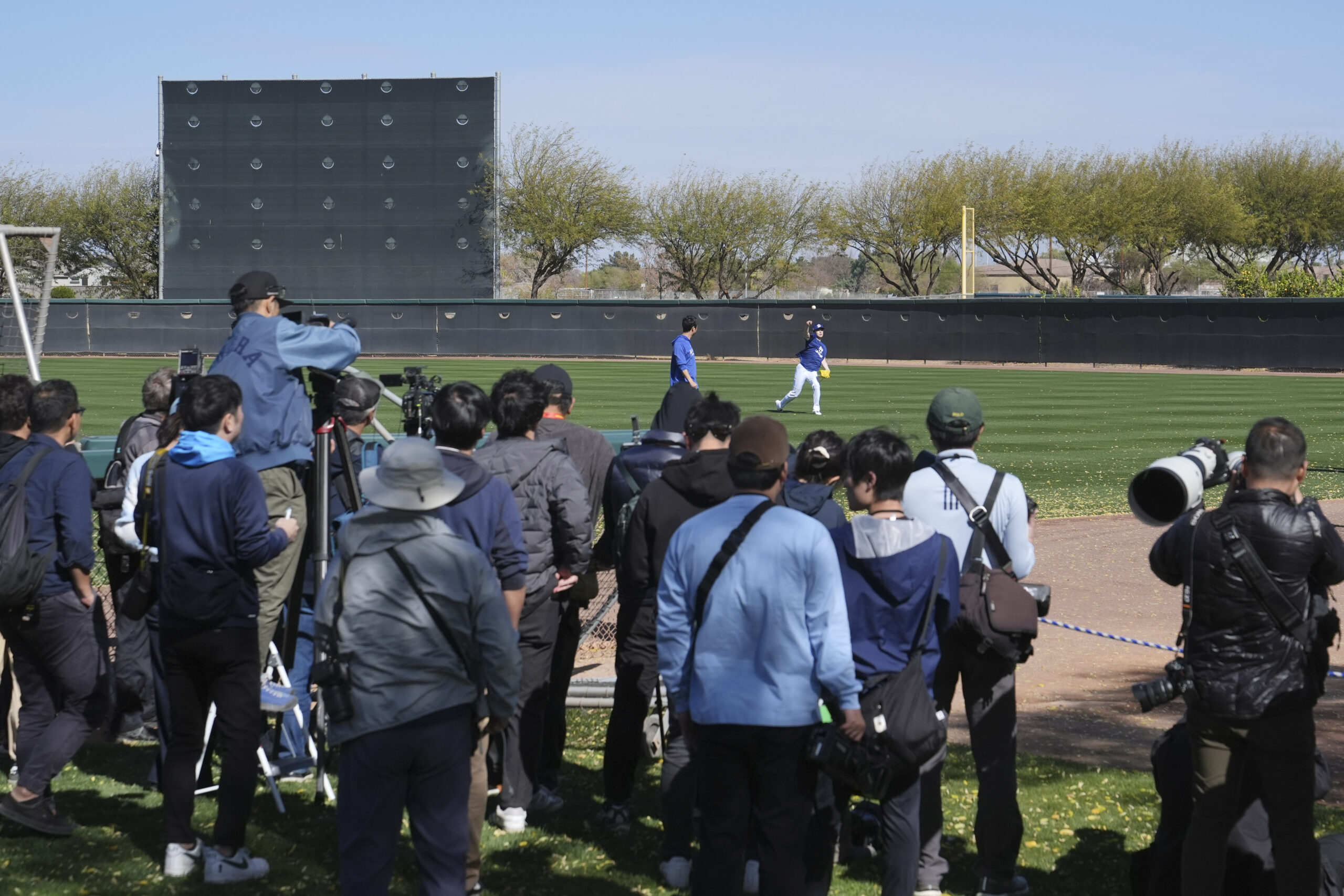 A large contingent of Japanese media watch Dodgers pitcher Roki...