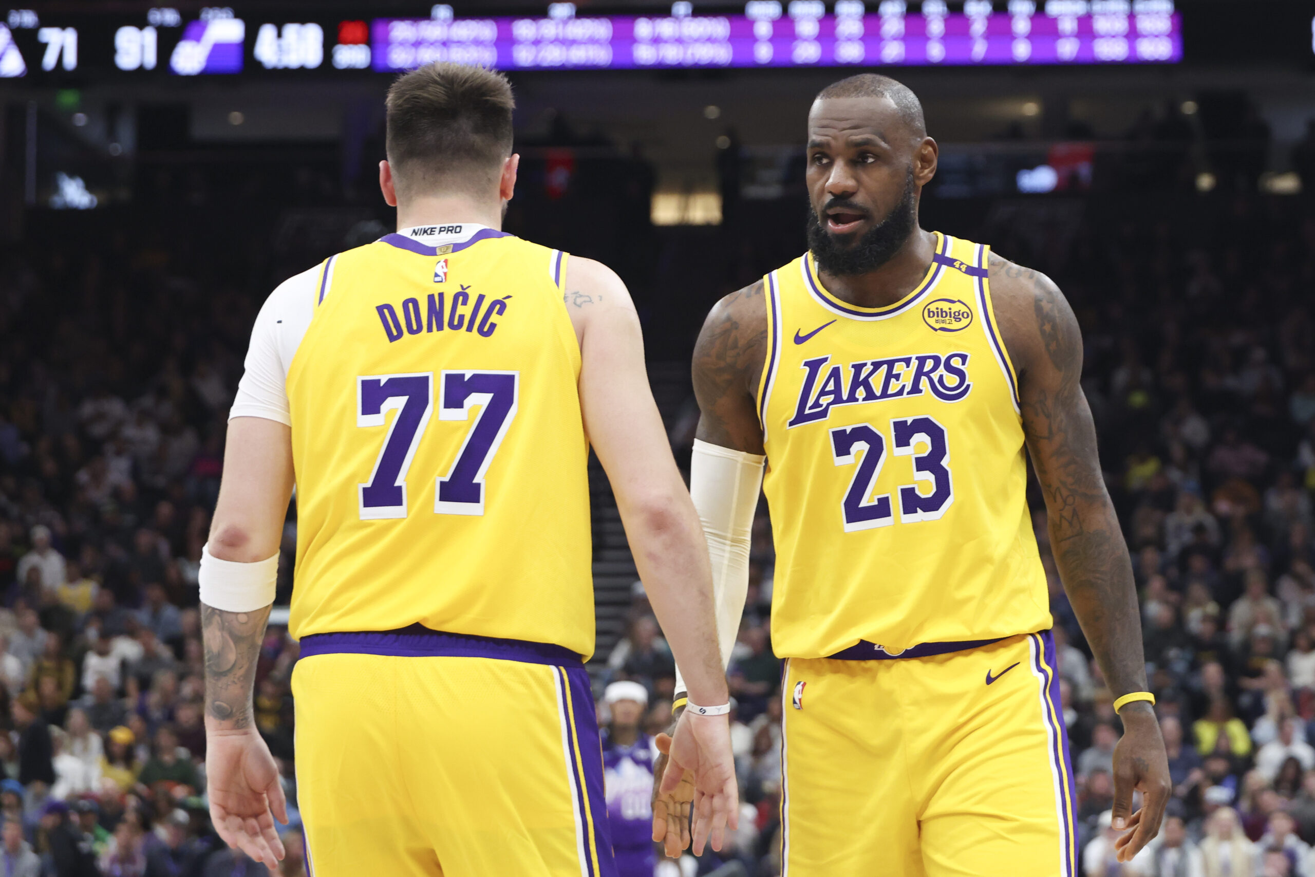 Lakers stars LeBron James, right, and Luka Doncic slap hands...