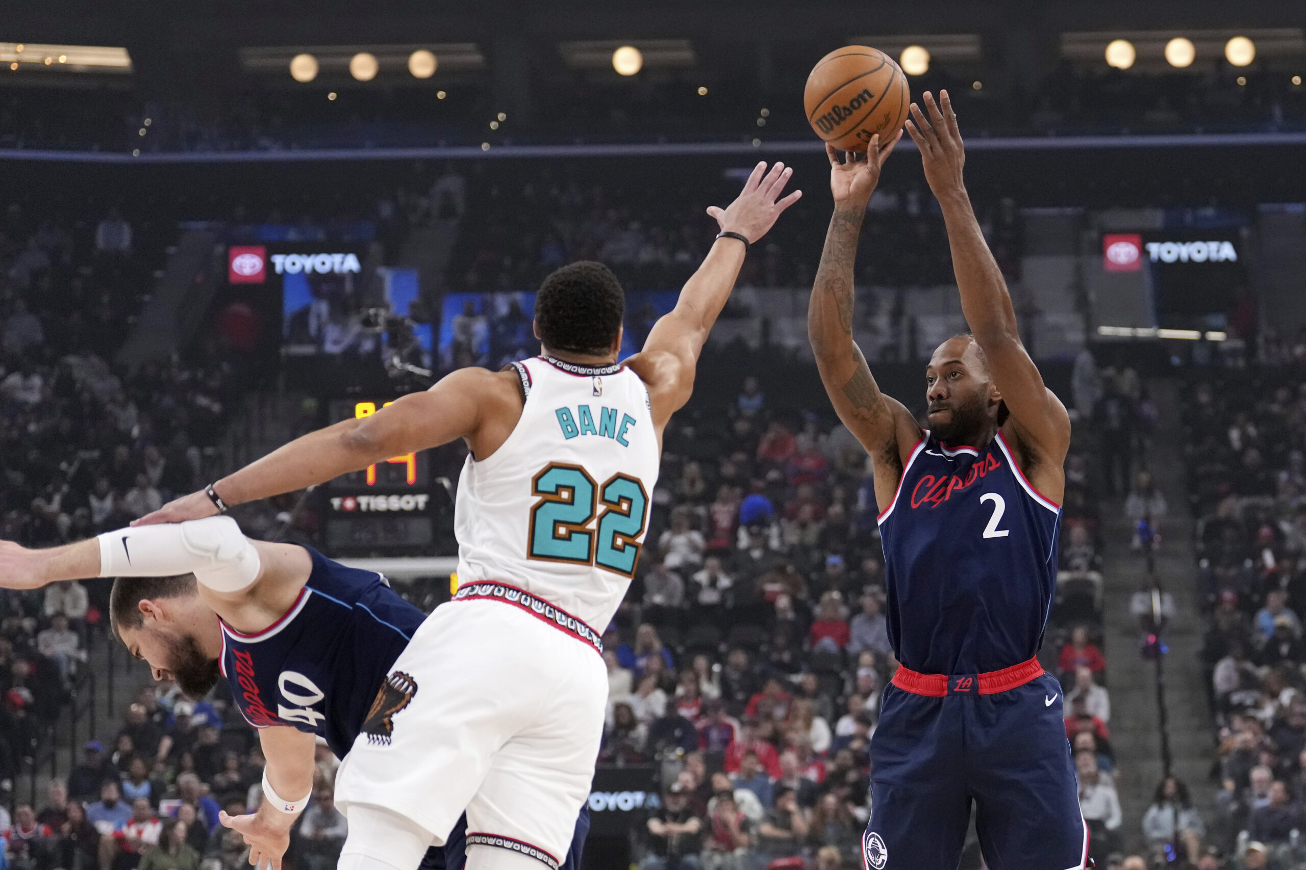 Clippers star Kawhi Leonard, right, shoots as Memphis Grizzlies guard...