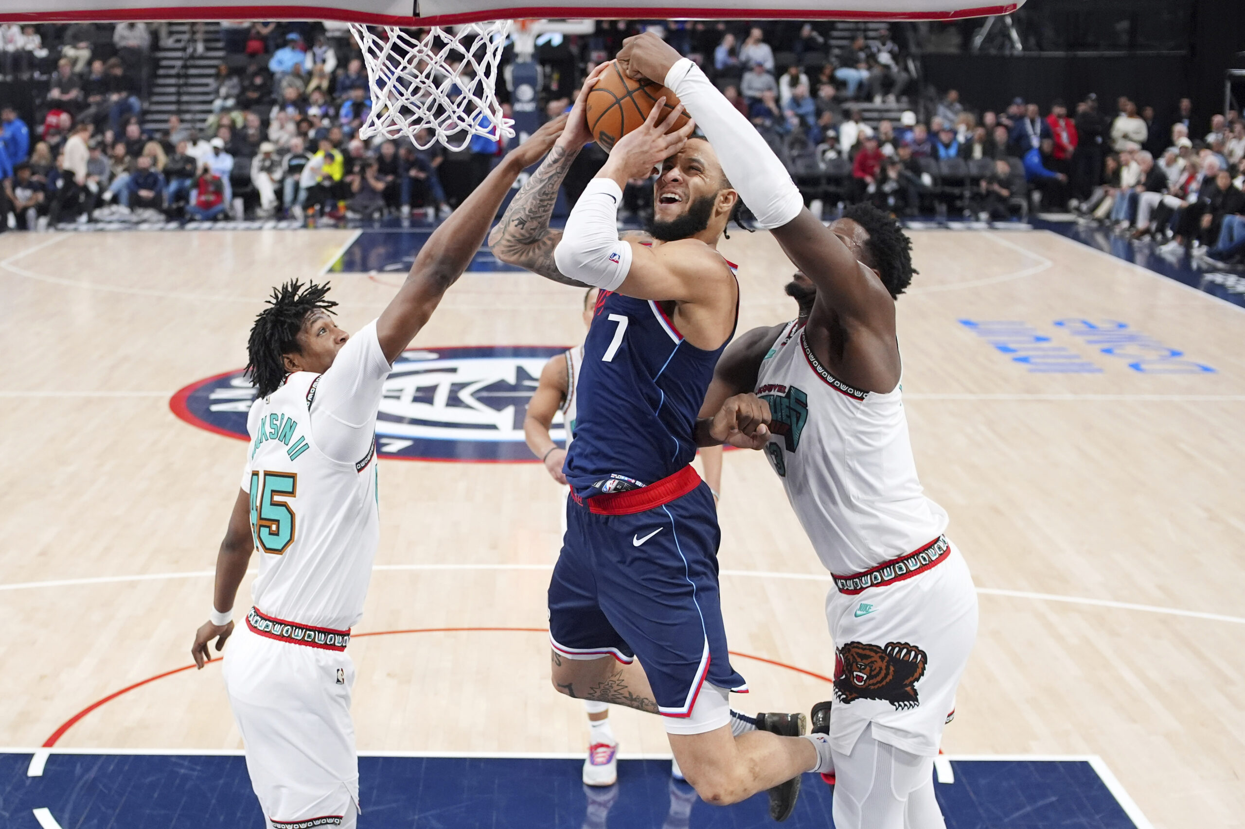 Clippers guard Amir Coffey, center, shoots as Memphis Grizzlies forward...