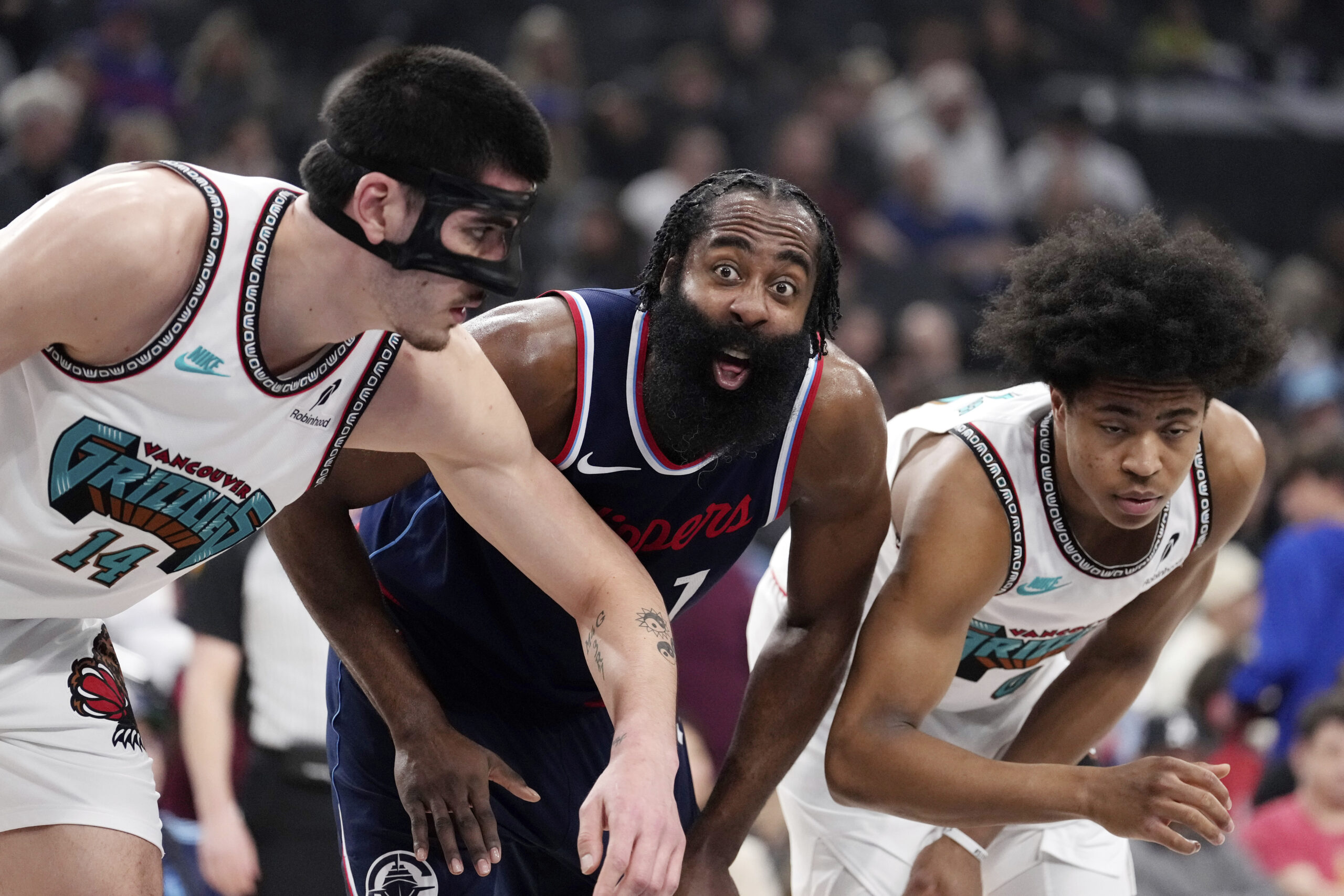 Clippers guard James Harden, center, talks to someone in the...