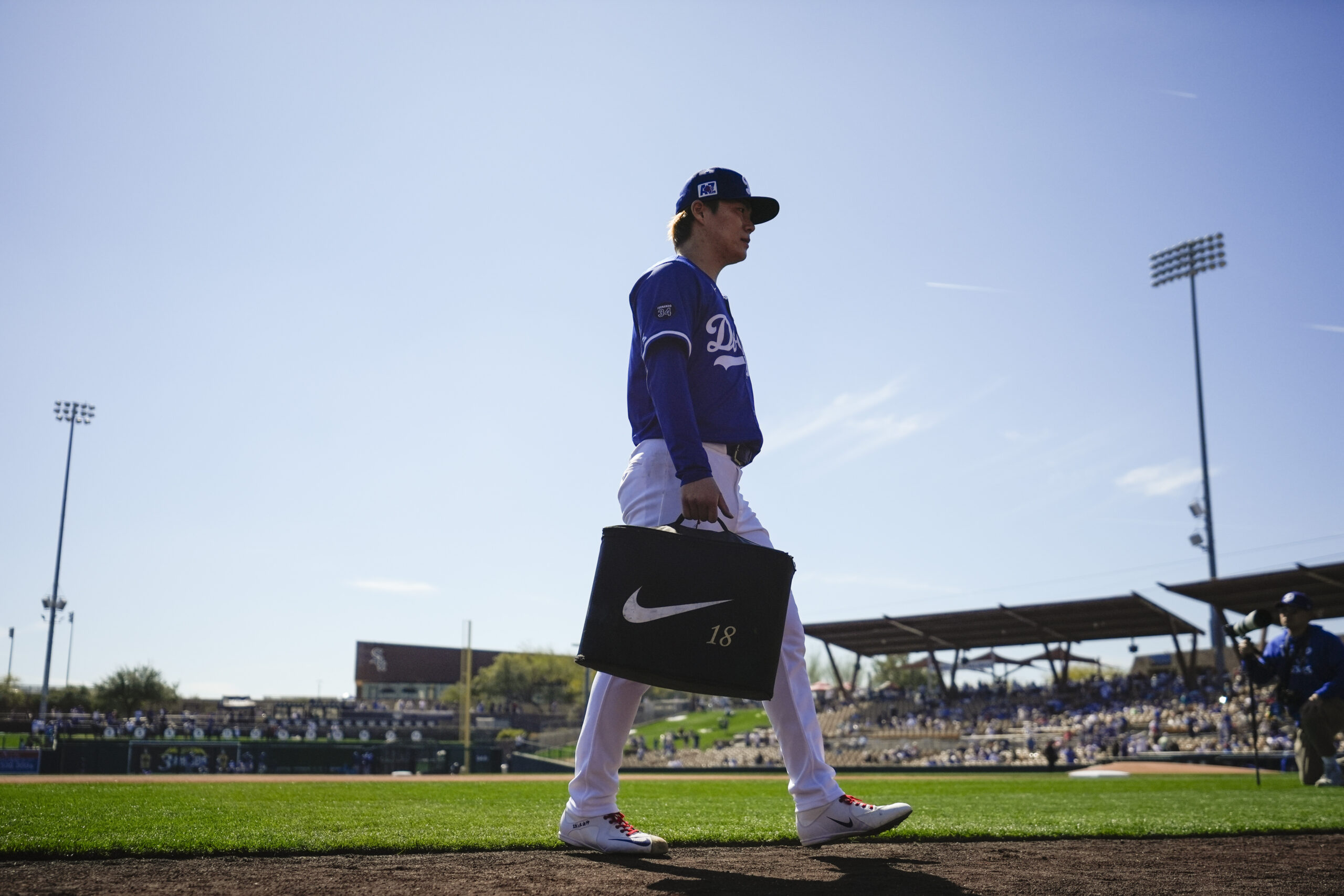 Dodgers starting pitcher Yoshinobu Yamamoto walks to the dugout before...