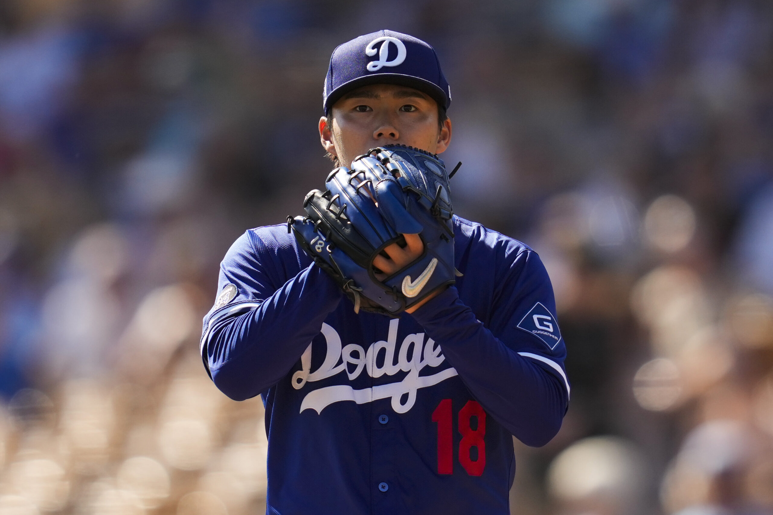 Dodgers starting pitcher Yoshinobu Yamamoto stands on the mound during...