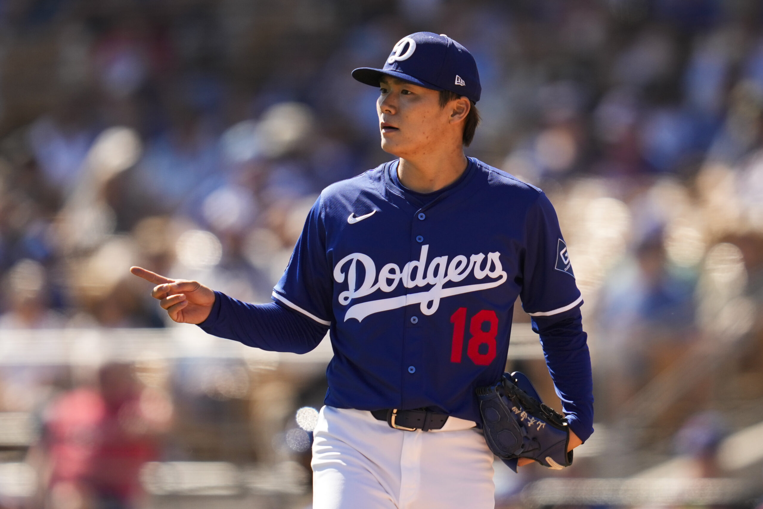 Dodgers starting pitcher Yoshinobu Yamamoto stands on the mound during...