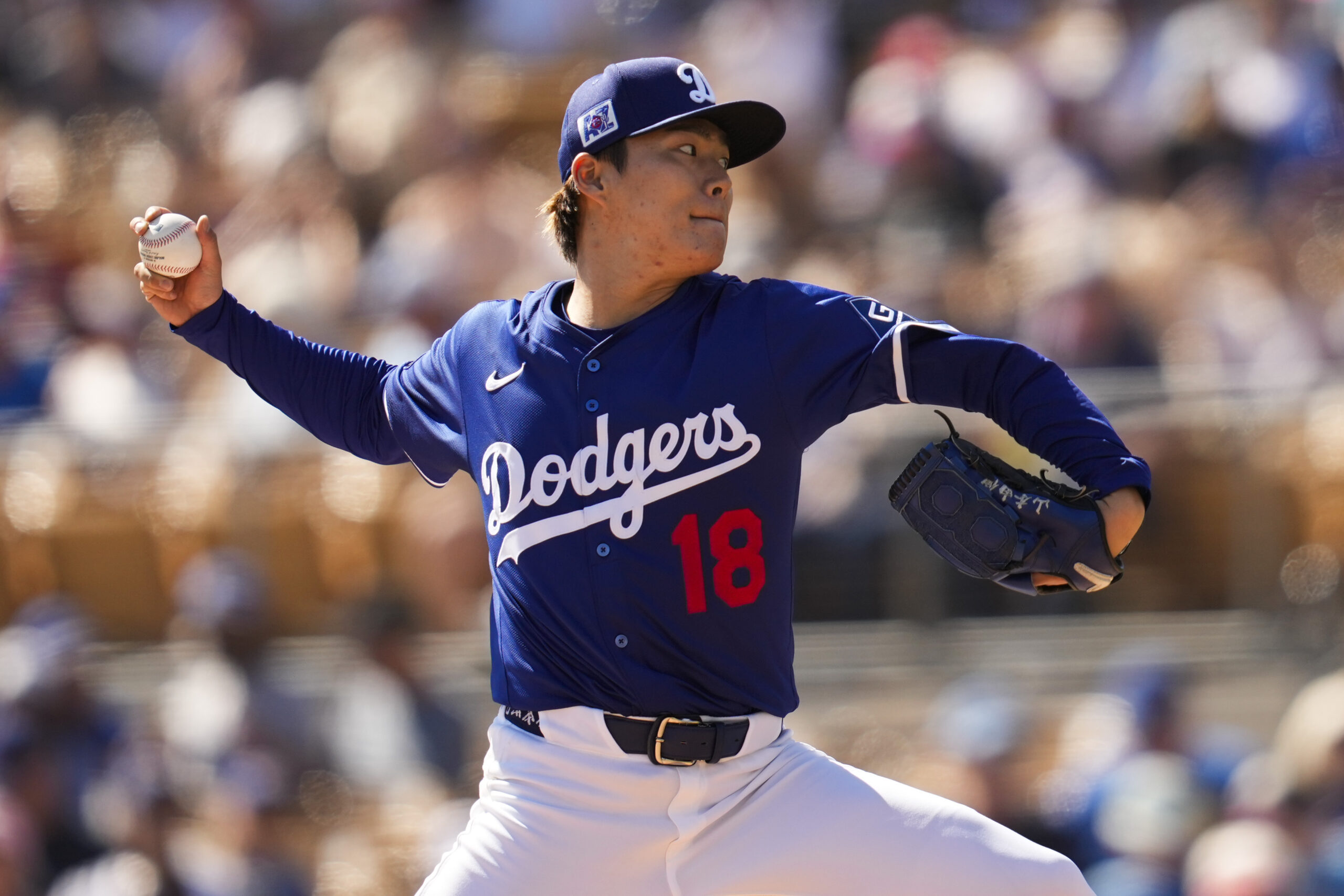 Dodgers starting pitcher Yoshinobu Yamamoto throws to the plate during...