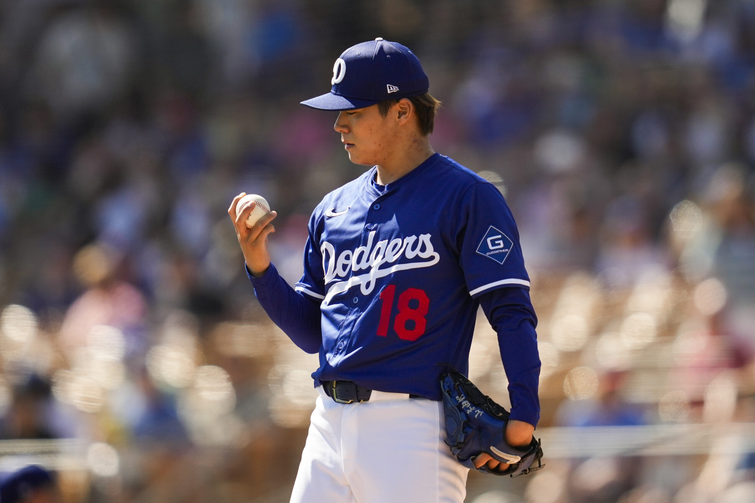 Dodgers starting pitcher Yoshinobu Yamamoto stands on the mound during...