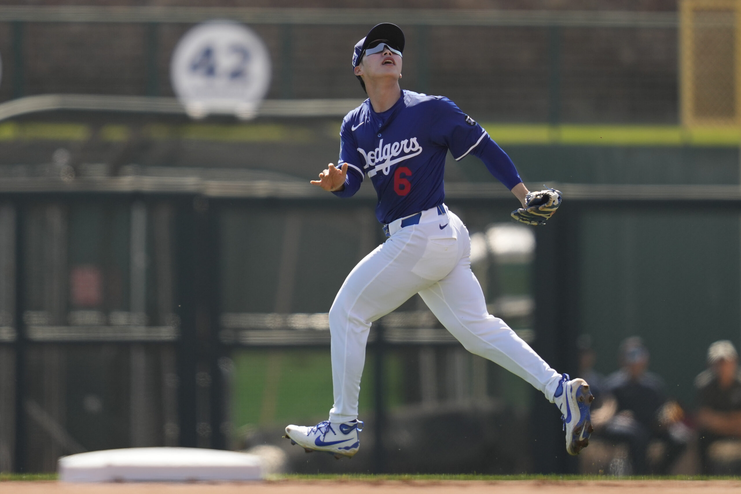 Dodgers second baseman Hyeseong Kim runs to catch a fly...