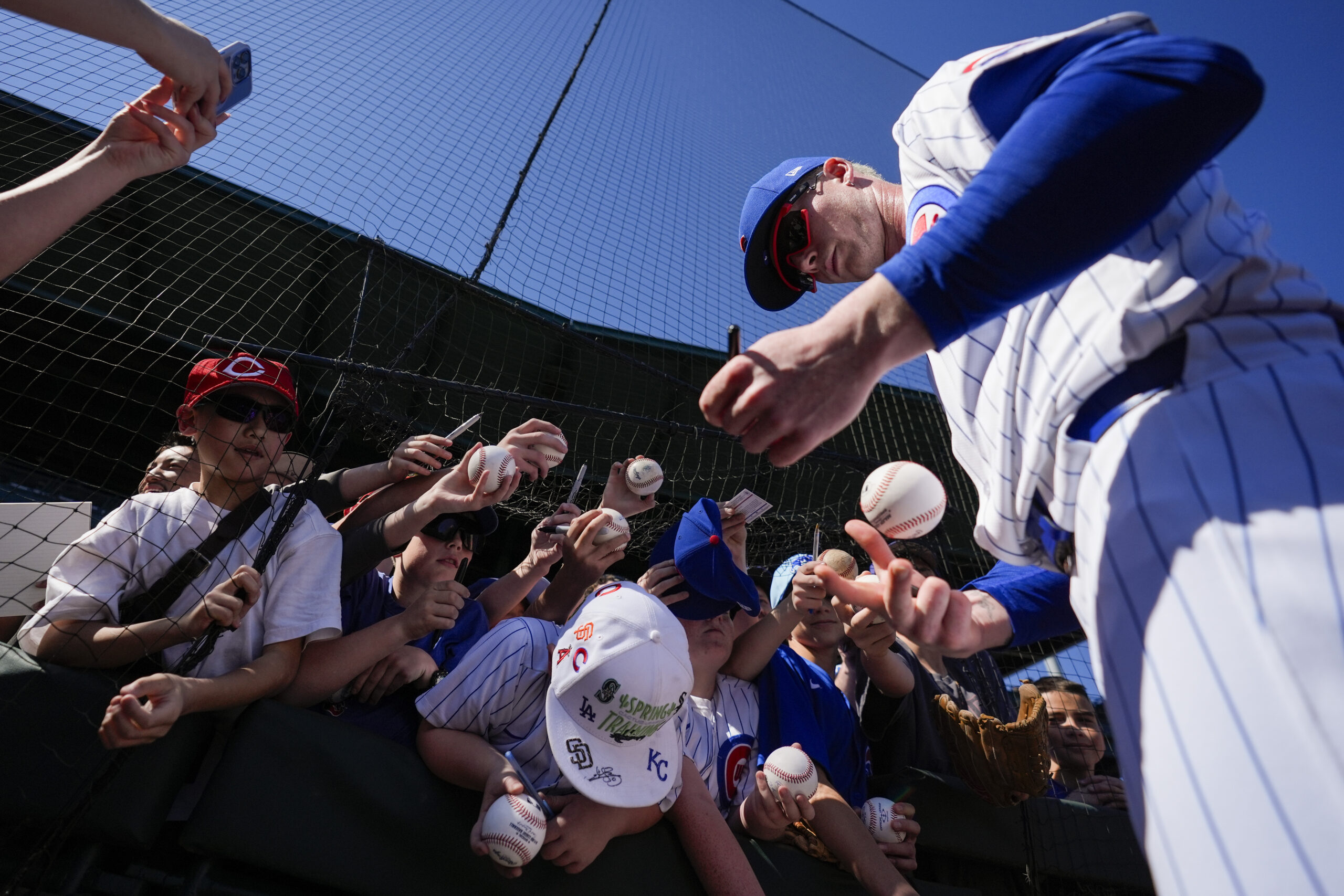 Chicago Cubs center fielder Pete Crow-Armstron, right, signs autographs for...