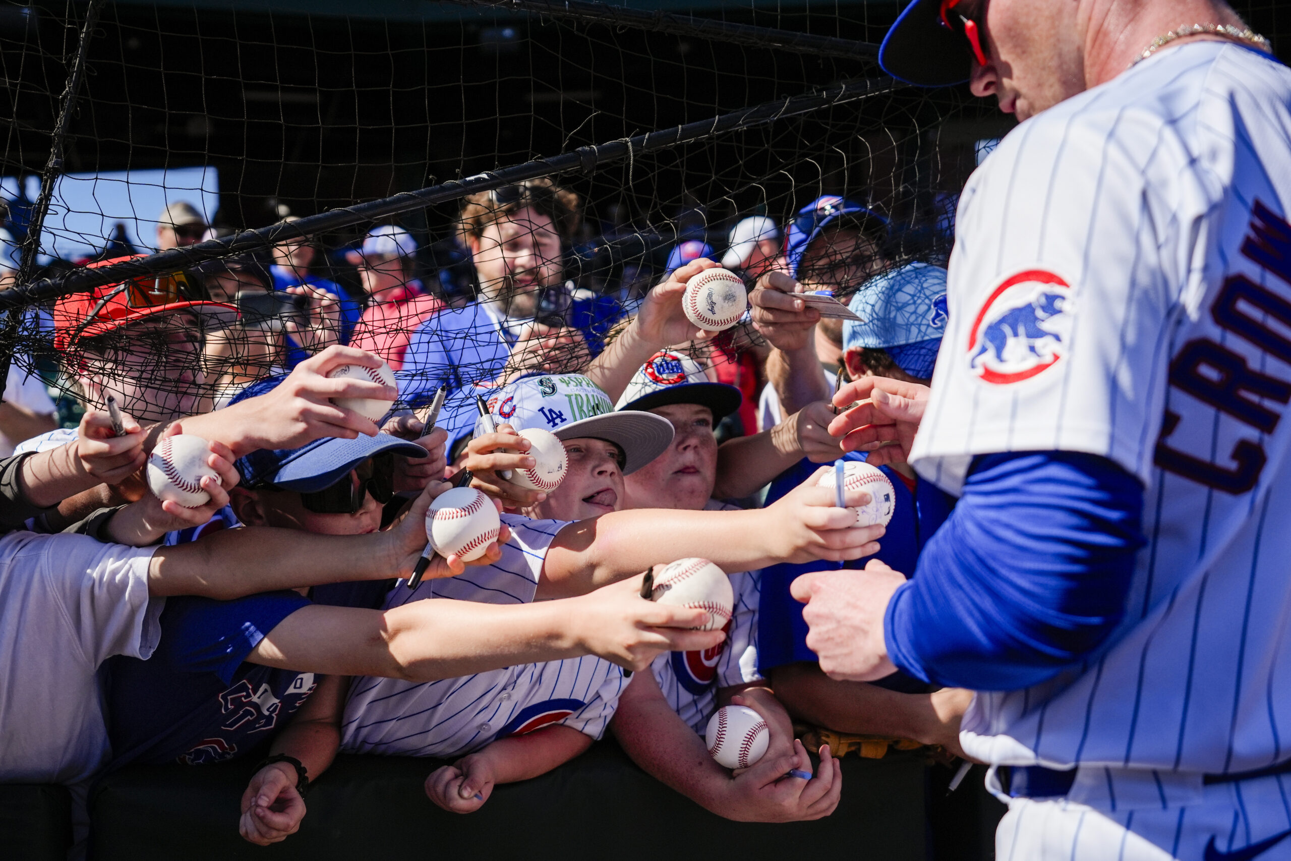 Fans reach to get an autograph from Chicago Cubs center...