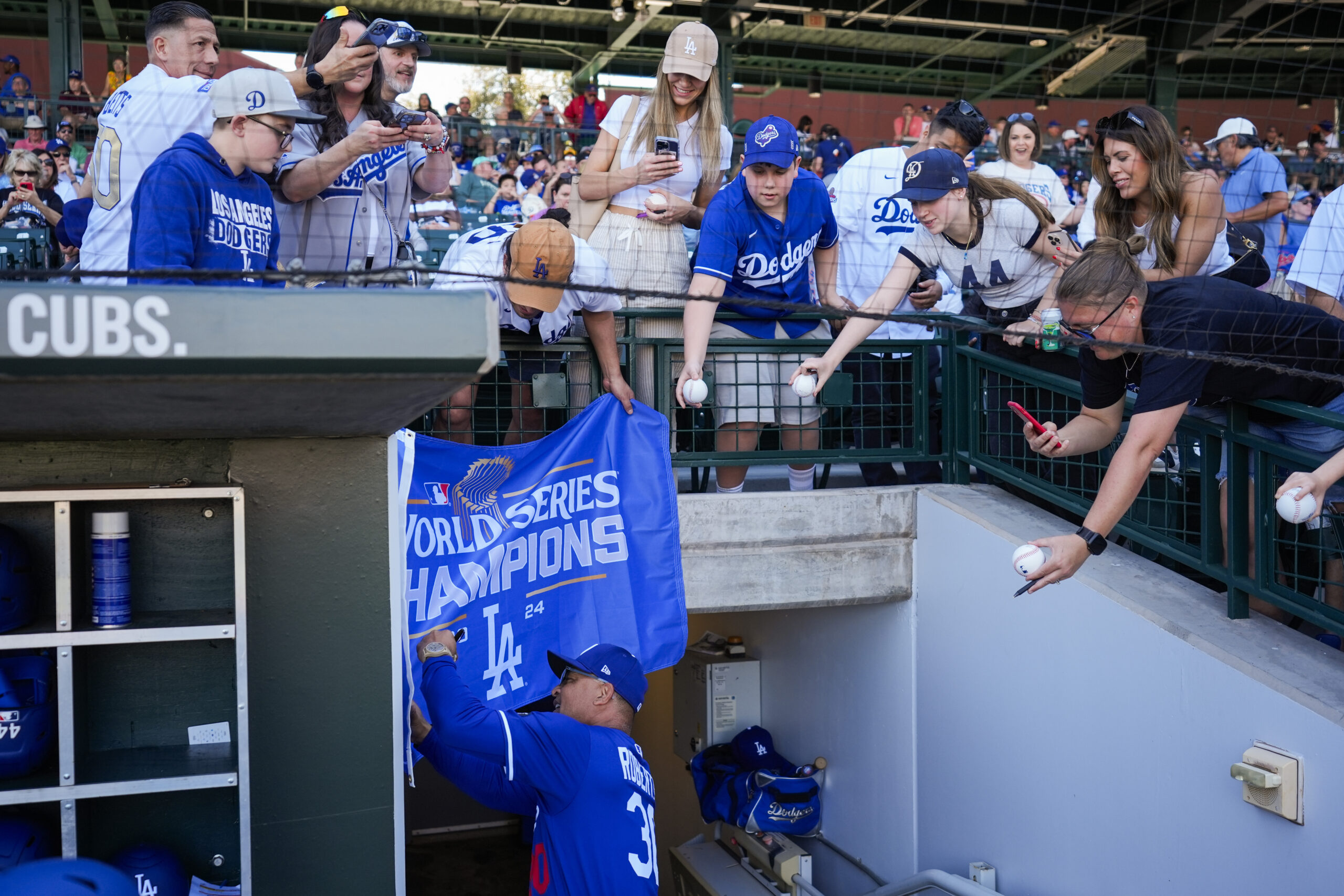 Dodgers manager Dave Roberts signs autographs for fans before a...