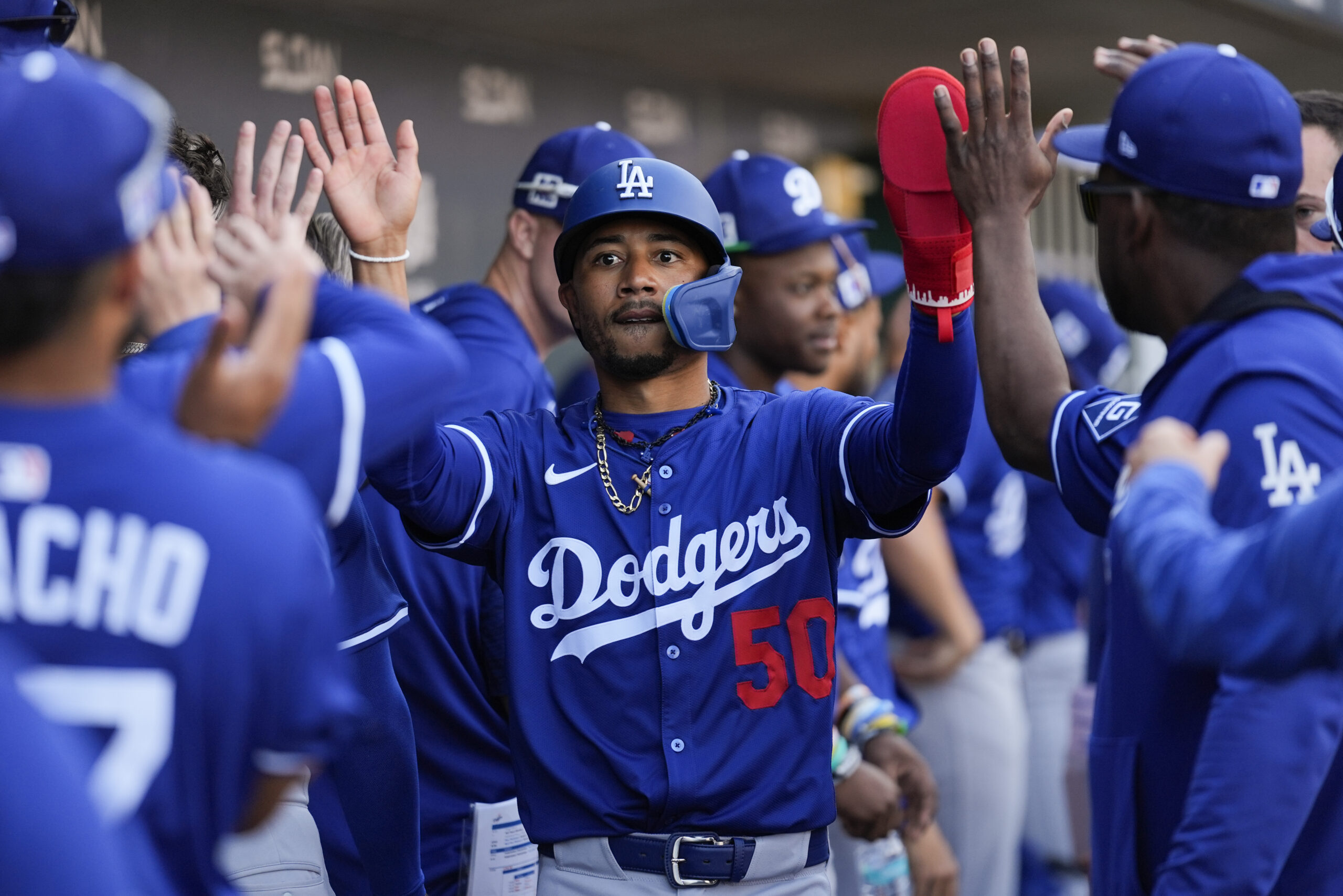 Dodgers star Mookie Betts celebrates in the dugout after scoring...